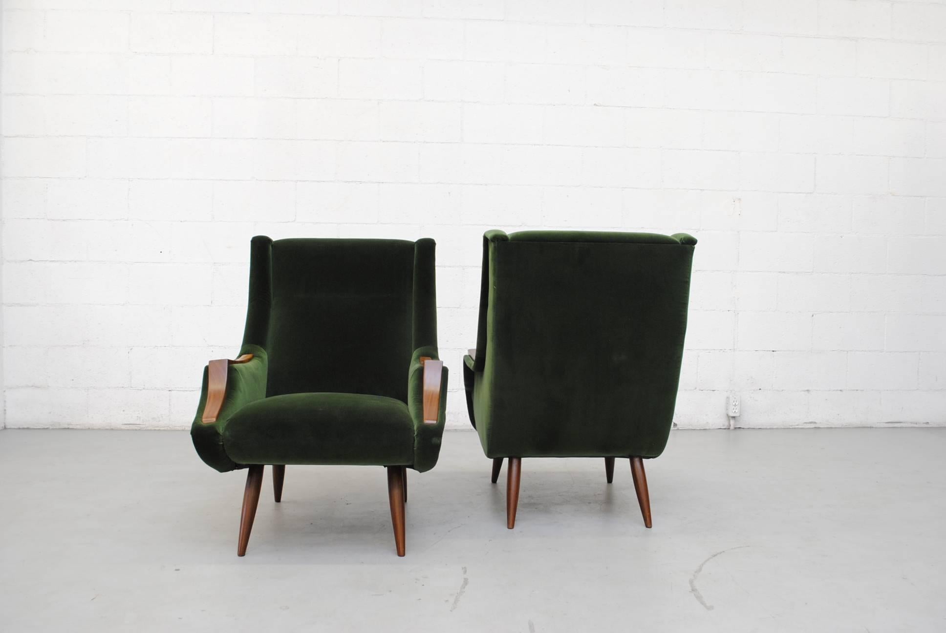 Set of two Marco Zanuso style lounge chairs newly upholstered in emerald green velvet with organic carved teak arm rests and legs, both lightly refinished. Set price.