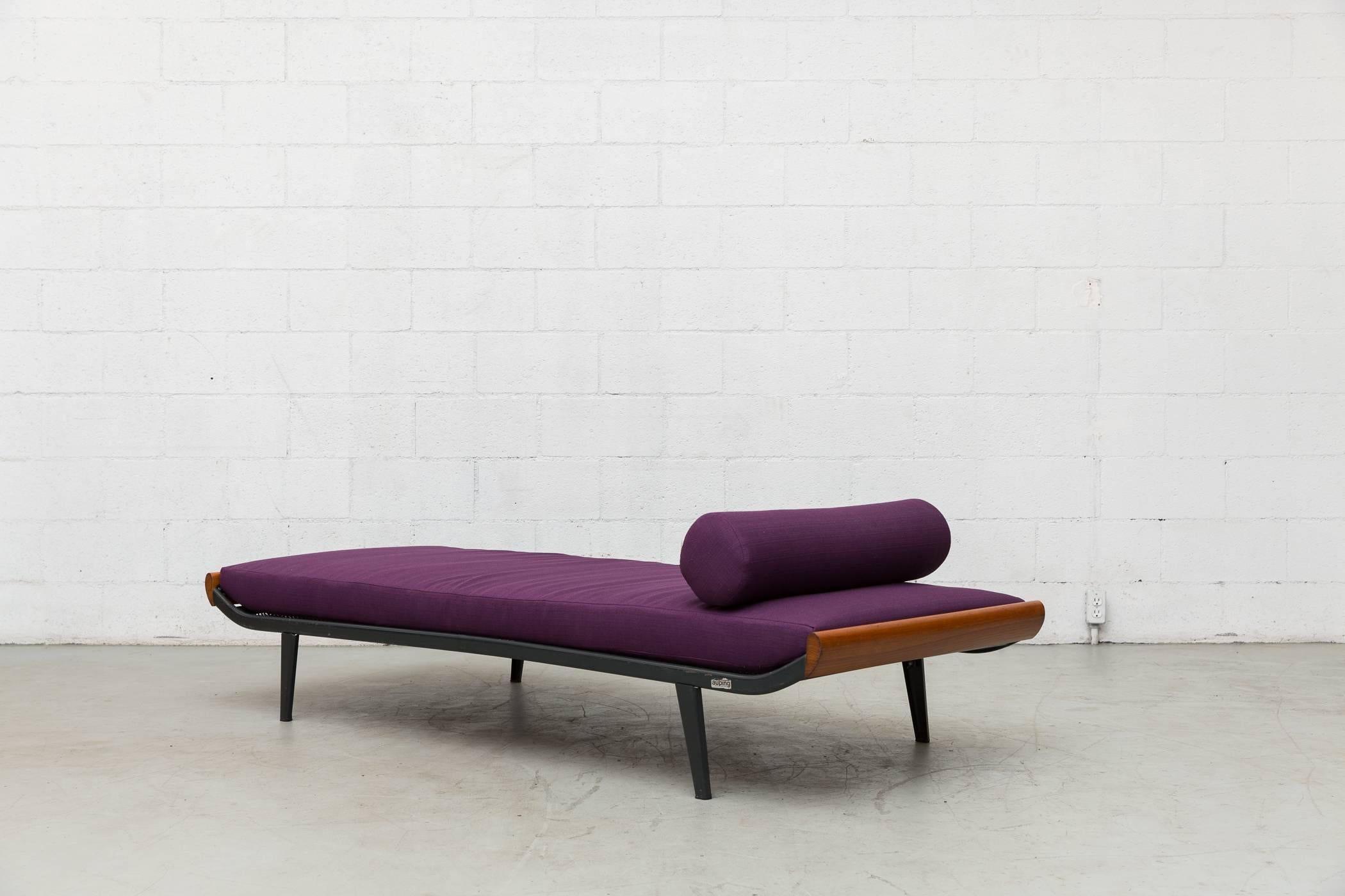 1960s Cleopatra daybed by A.R. Cordemeyer. Teak wood ends with enameled dark grey metal frame and Auping printed on mesh springs. New plum upholstered mattress and matching bolster. Frame in original condition with visible scratching to the enameled