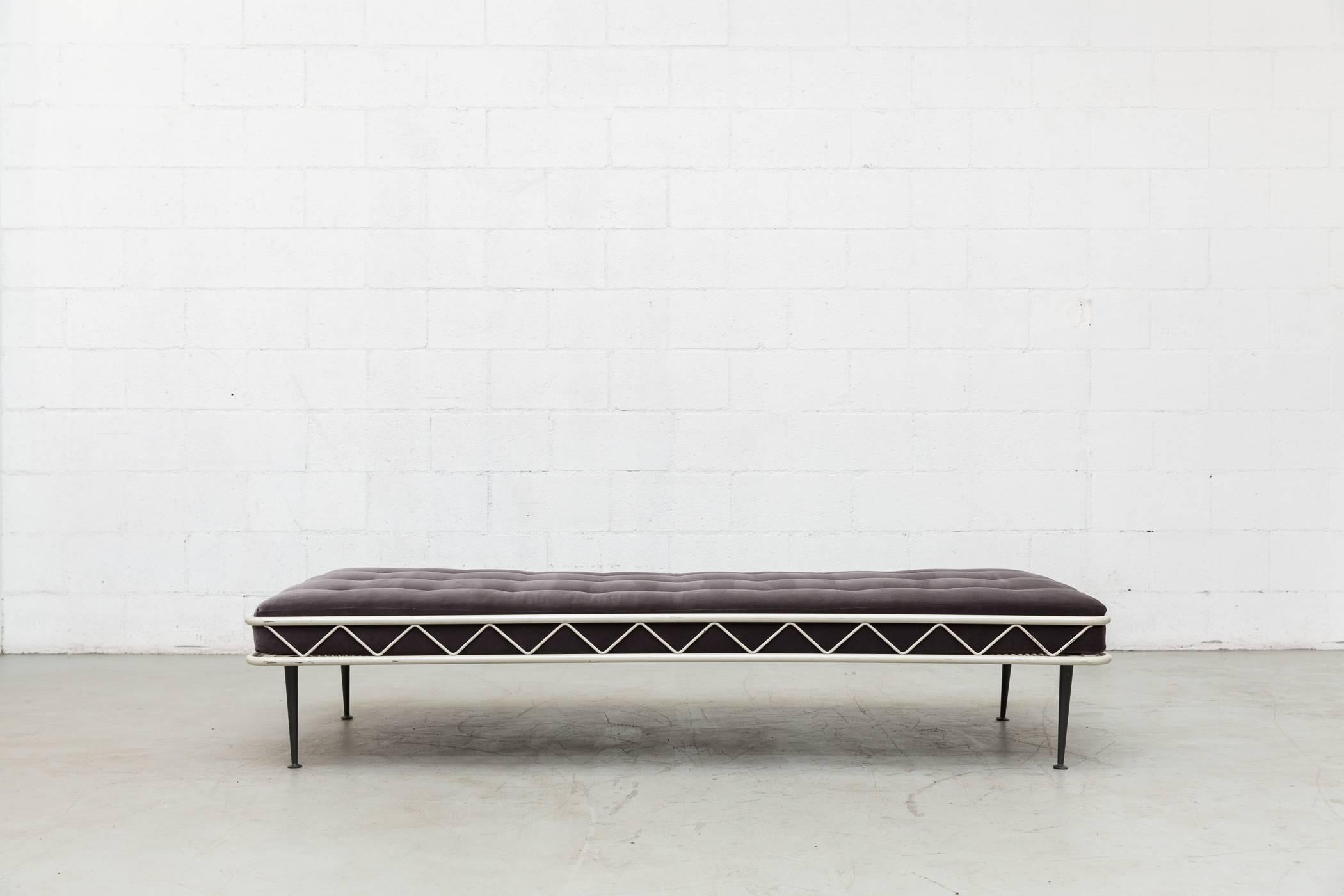 Architectural light grey enameled metal daybed with newly made tufted grey velvet mattress and dark charcoal grey metal legs. Frame in original condition with visible wear consistent with its age and usage.