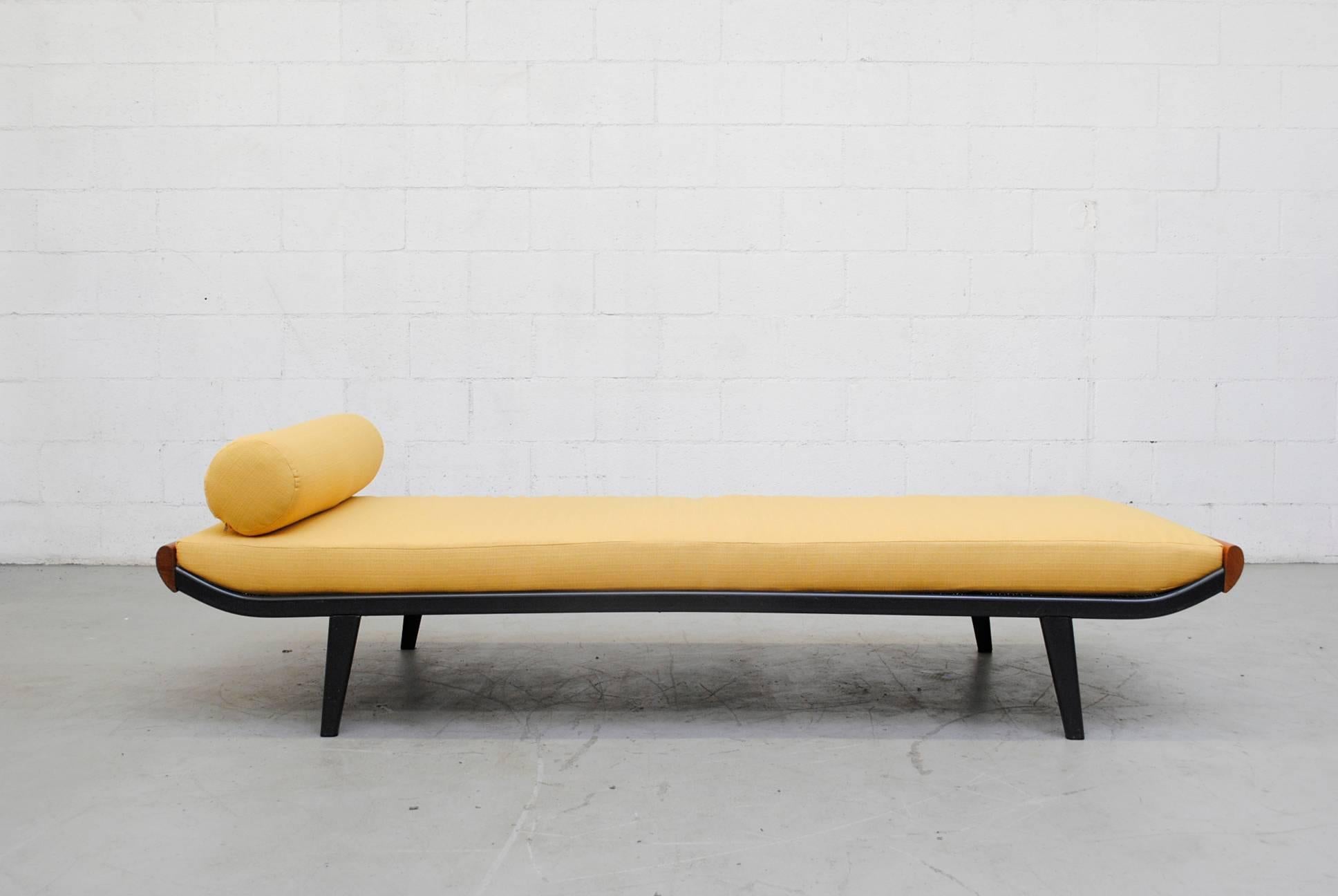 1960s Cleopatra daybed by A.R. Cordemeyer. Wood ends with enameled dark grey metal frame and Auping printed on mesh springs. New yellow upholstered mattress and matching bolster. Frame in original condition with visible scratching to the enameled
