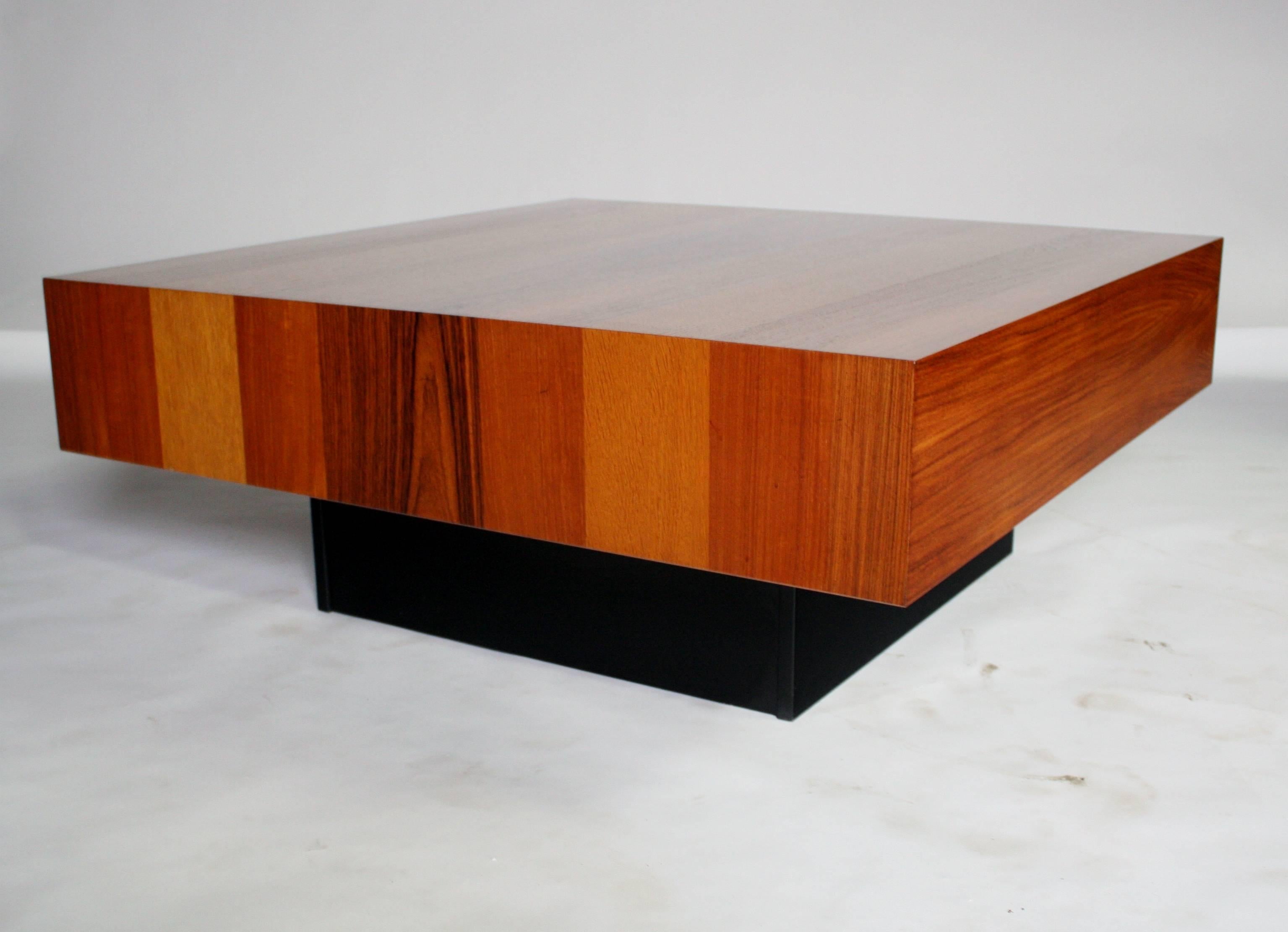 Square wood coffee table by Drylund of Denmark designed in a parquetry of rosewood, palisander, teak and maple resting on a black lacquered cube base. Remarkably excellent condition.