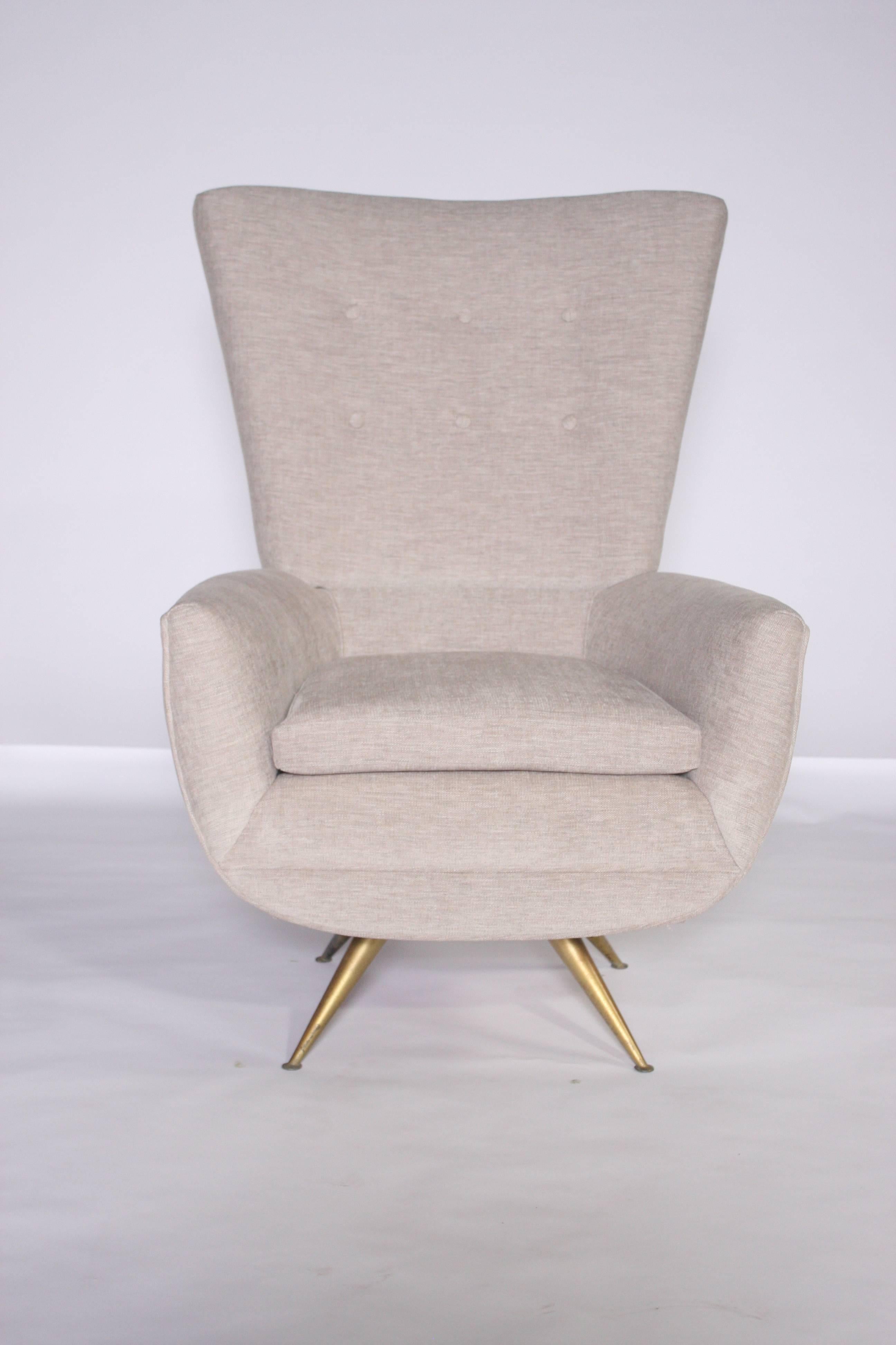Rare freshly upholstered Mid-Century Modern swivel lounge chair by Chicago architect Henry Glass (1911-2003) with brushed gold metal tapered legs and tall tufted back cushion. Upholstered in a subtle heather gray textured fabric with a removable