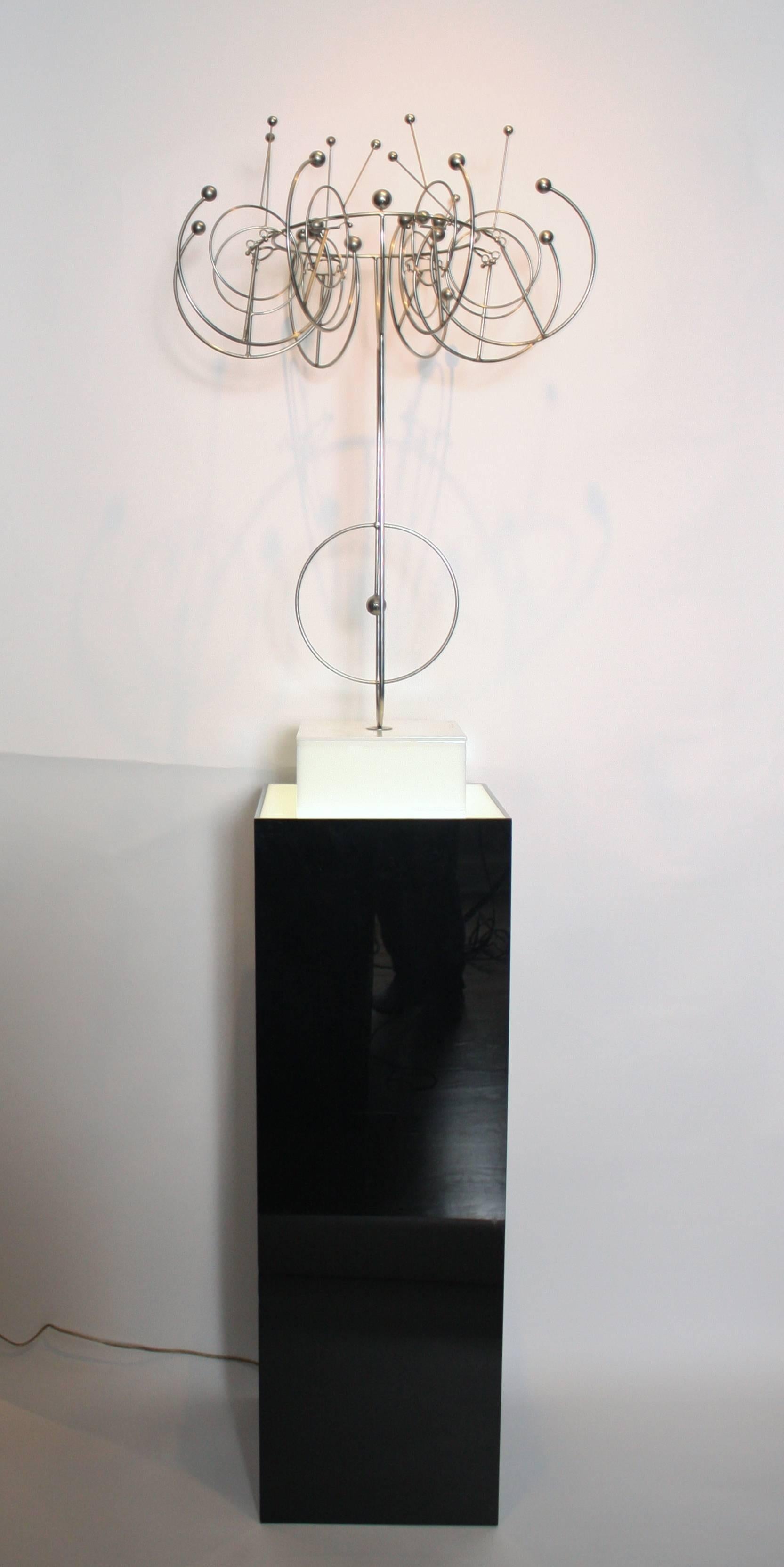 Large Kinetic welded wire sculpture by Industrial designer and sculptor, Joseph Burlini. Signed by the artist and dated (1982) on the white acrylic plinth. Included is the illuminating stand intended for this installation in black high gloss acrylic