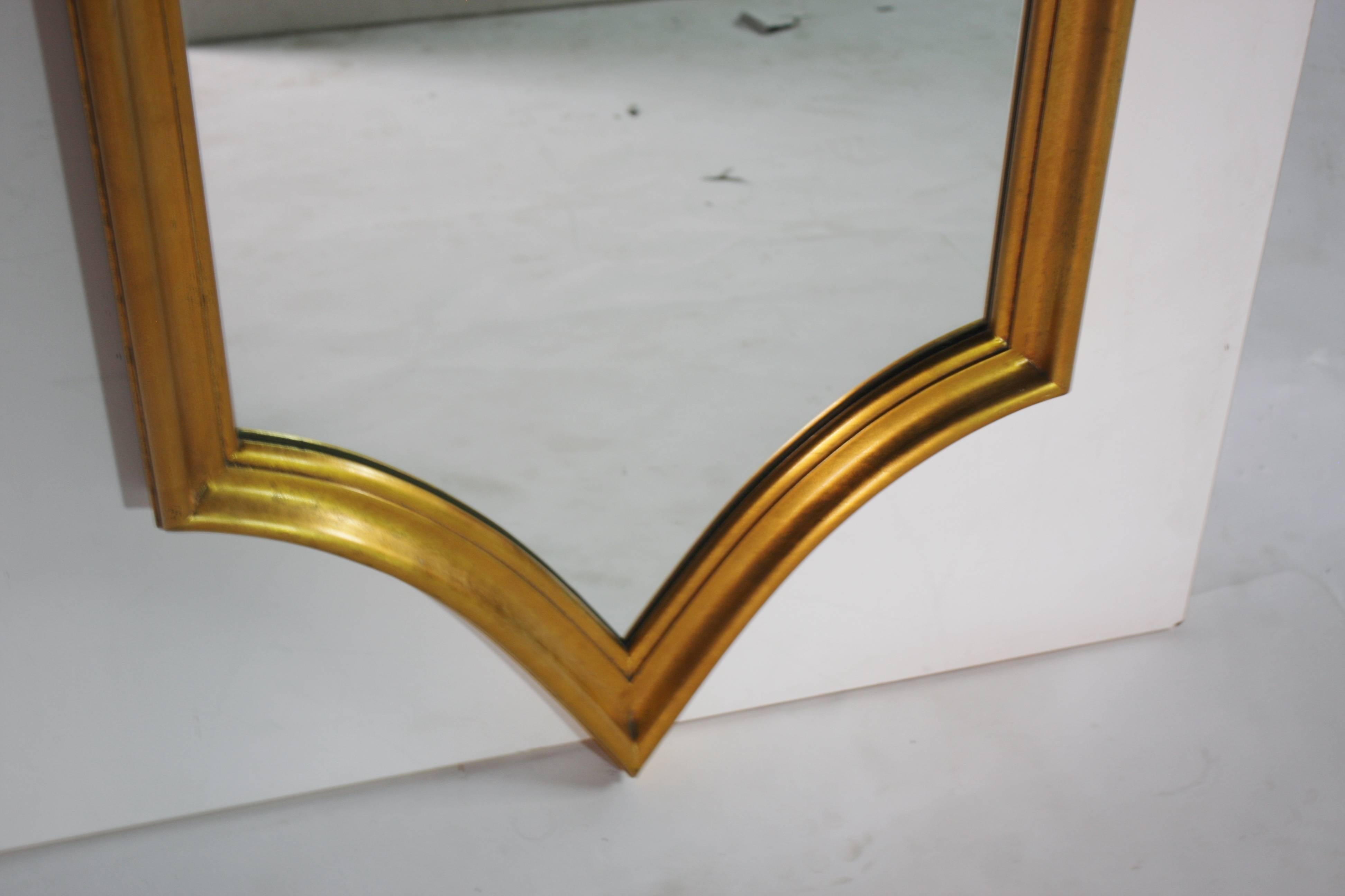 Mid-Century decorative gold giltwood mirror in a unique Hollywood Regency style.