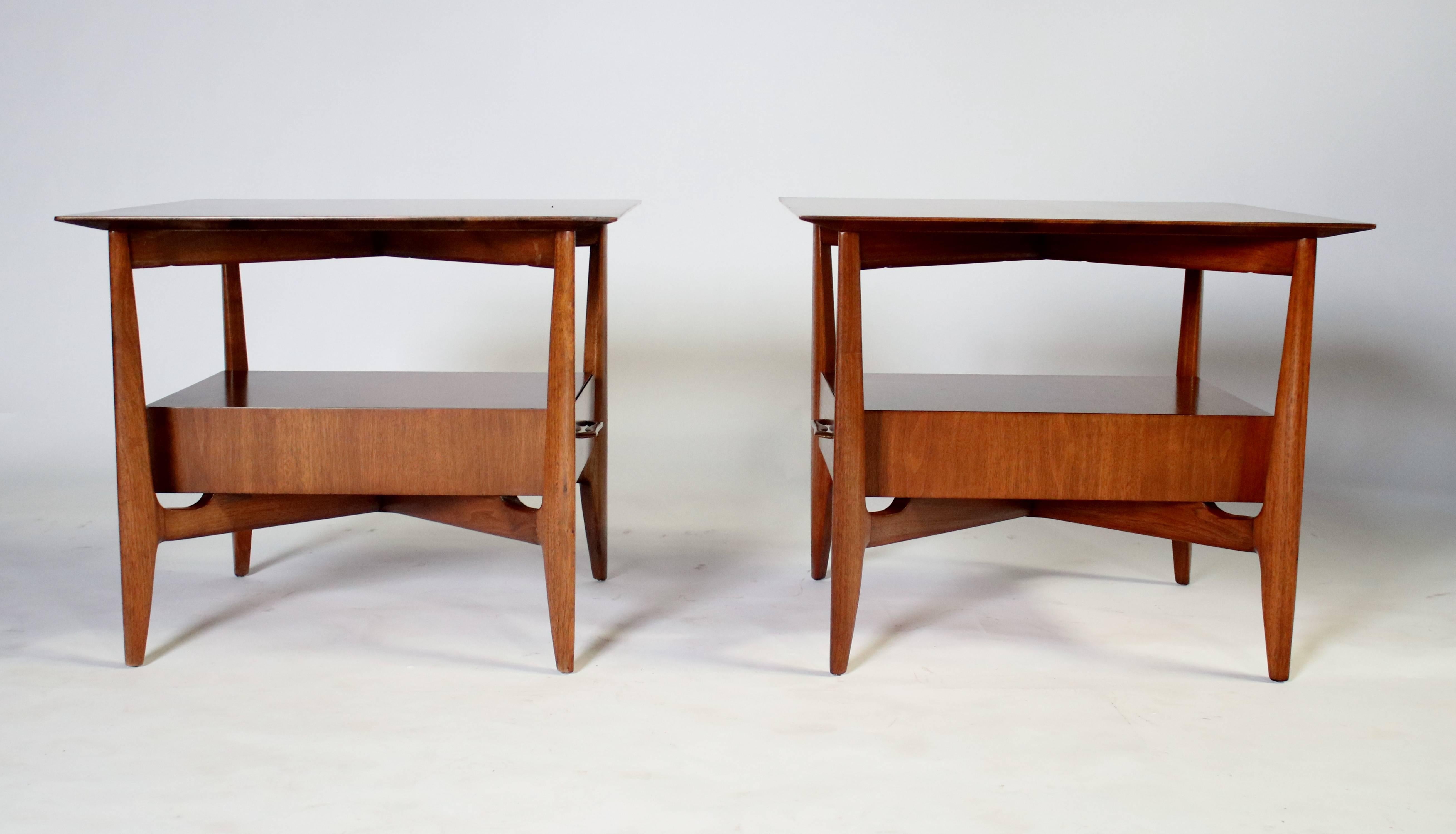 Pair of 1960s sculptural walnut end tables by John Stuart with a floating single drawer and original brass pulls.