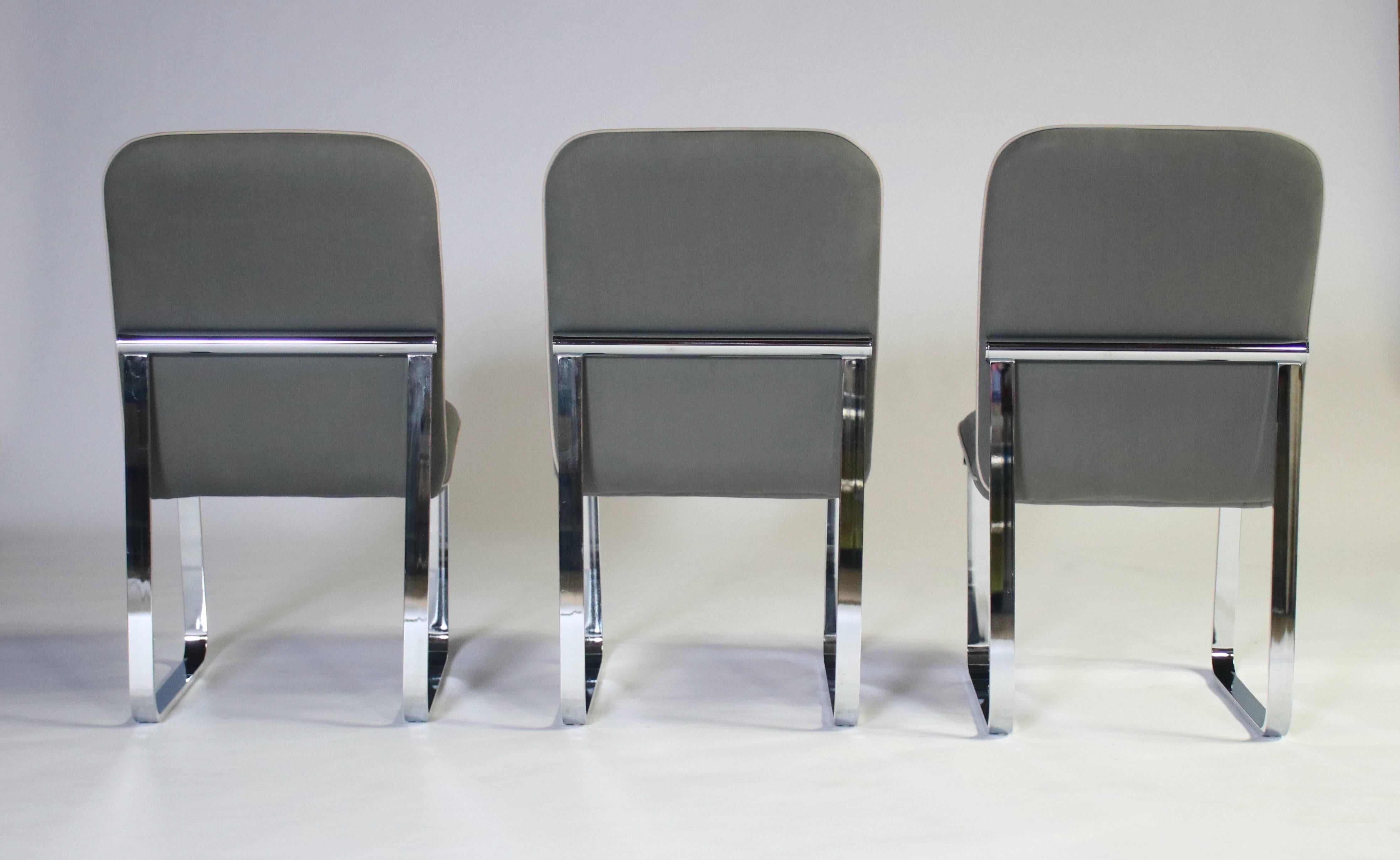 Trois chaises de salle à manger des années 1970 par Design Institute of America sur de lourds cadres chromés. Excellent état et tapisserie récente. Une des chaises présente une légère décoloration du tissu. Revêtement en coton gris avec passepoil