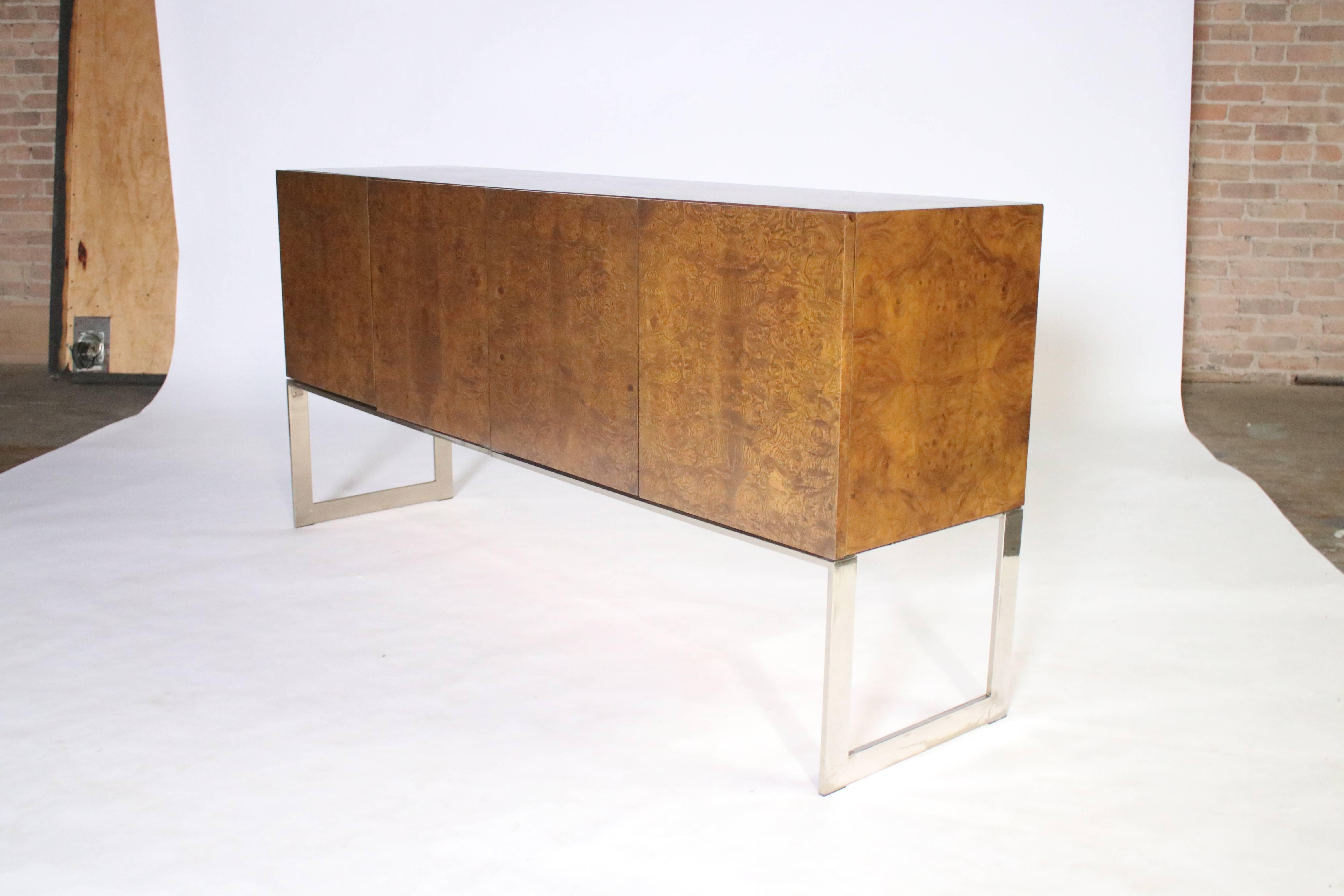 Milo Baughman for Thayer Coggin walnut burl wood credenza on polished chrome steel sled legs. Four cabinets open to a glass and a wood shelf on the left side and two pull-out drawers with felt lining for cutlery and silverware on the right side.