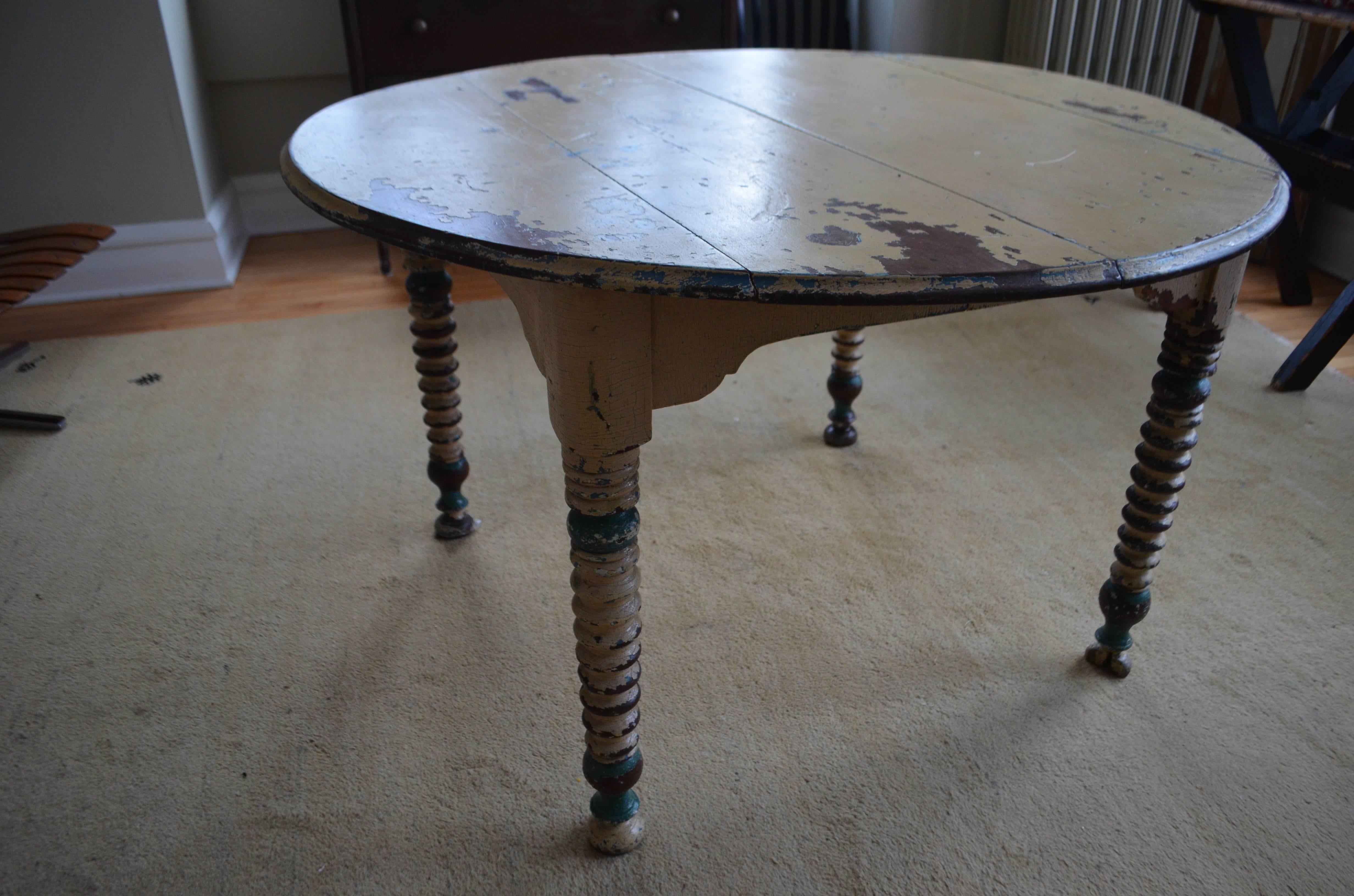 Simple round wood table with chippy paint of cream, brown and blue-greens. Spool turned legs. Sturdy yet worn-to-perfect. Soft and romantic. 23.5