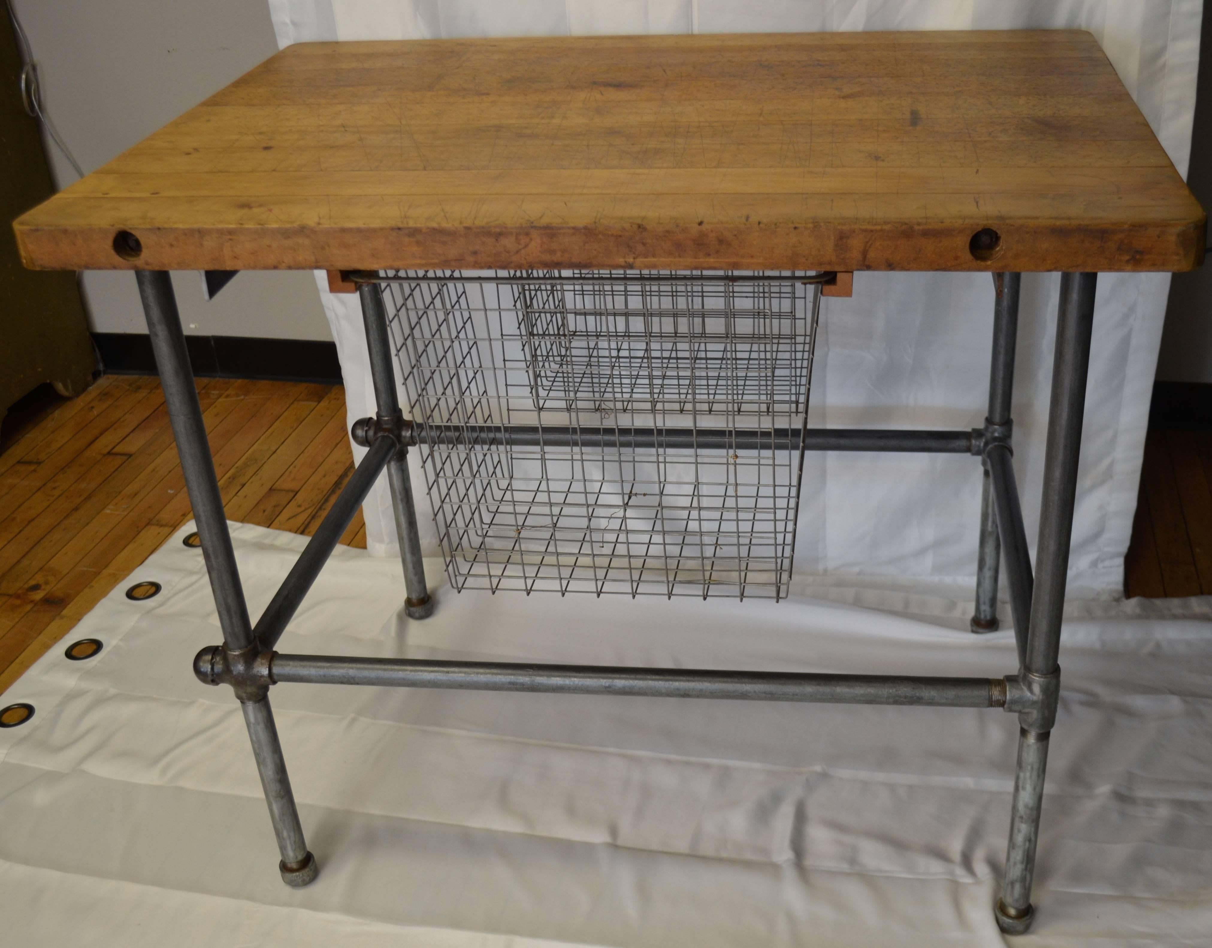 Kitchen island with maple top and two sliding baskets mounted beneath. Sits atop sturdy, interlocking, steel pipe base and legs. Piece is cleaned and sealed to preserve patina of top and legs. Spare, elegant and highly functional.