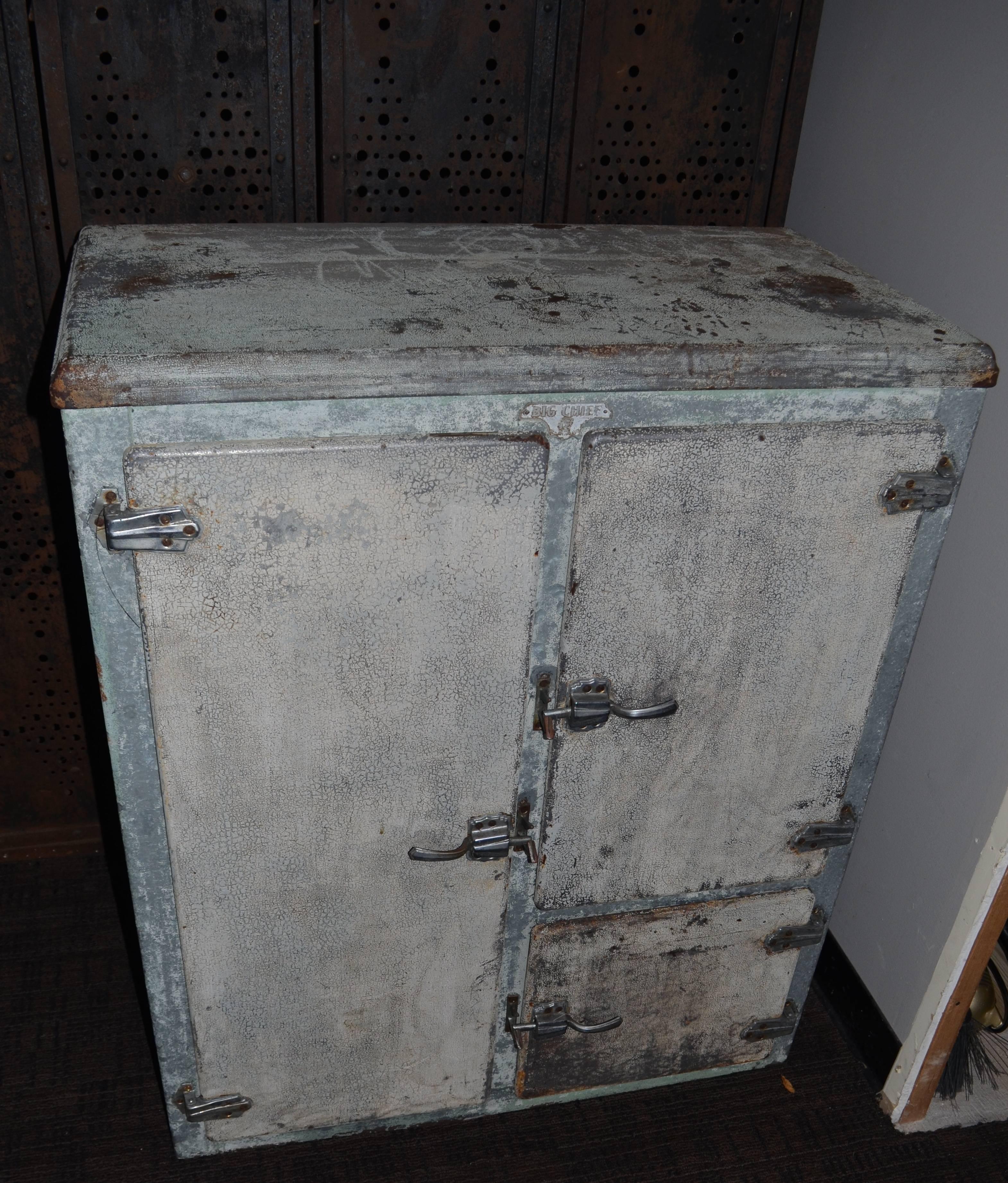 1920s big chief refrigerator makes a neat home bar and storage cabinet. Tactile, paint patina has been cleaned and sealed with clear acrylic. Doors latch tightly with steel shelves inside.