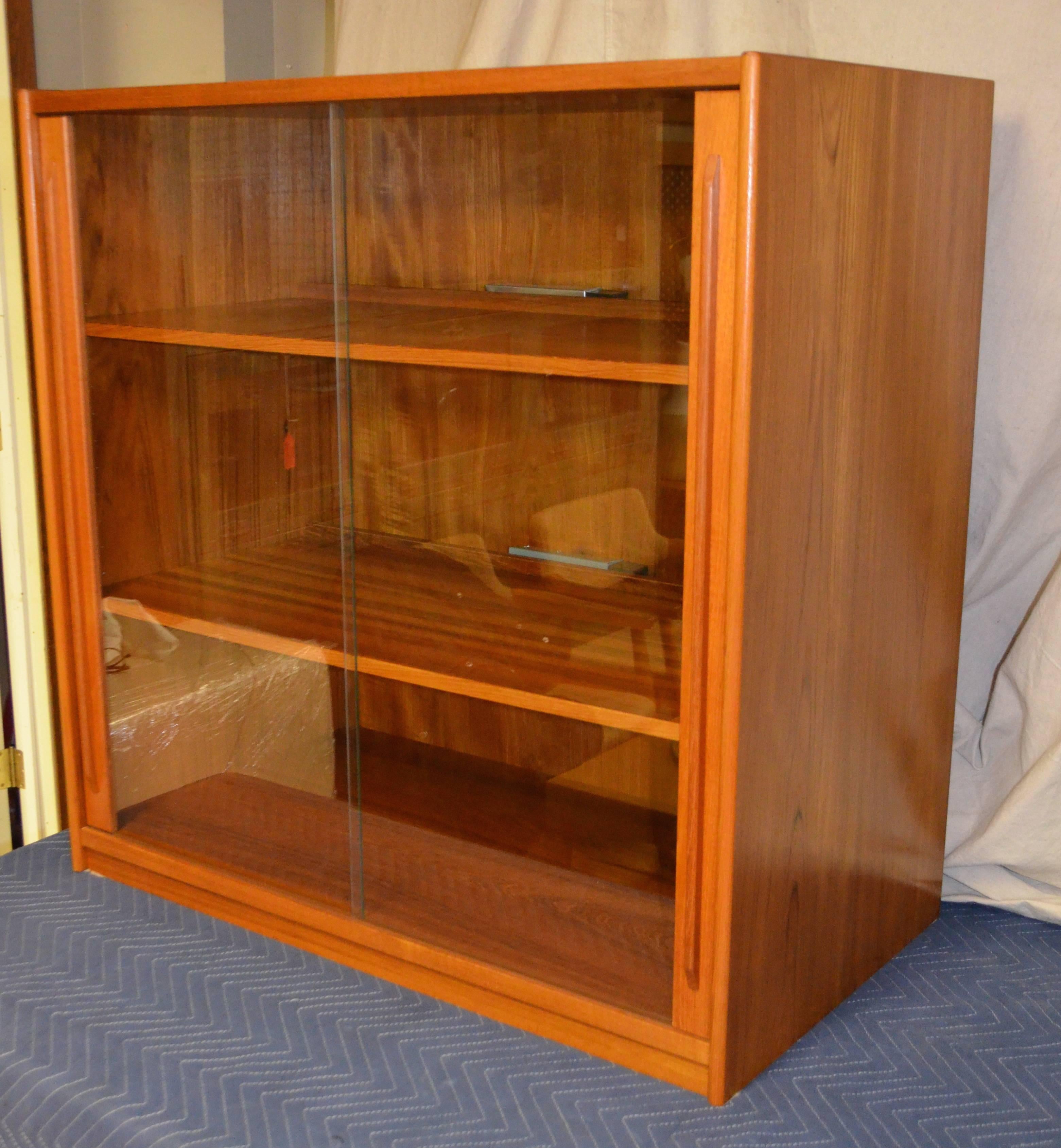 Midcentury teak storage cabinet from Denmark. Wired for electronics with sliding glass doors. A Classic period piece in great shape. Highly functional.