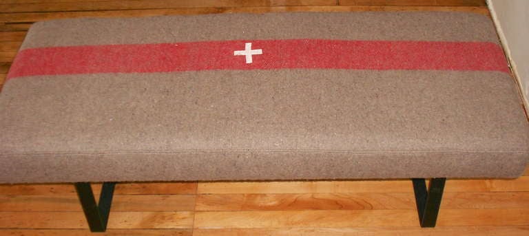 Bench upholstered in a vintage Swiss Army blanket sits atop curved steel legs. Blanket is part of new or old stock found in storage in Switzerland after WWII. Commissioned for field and hospital use during the war, these blankets were never employed