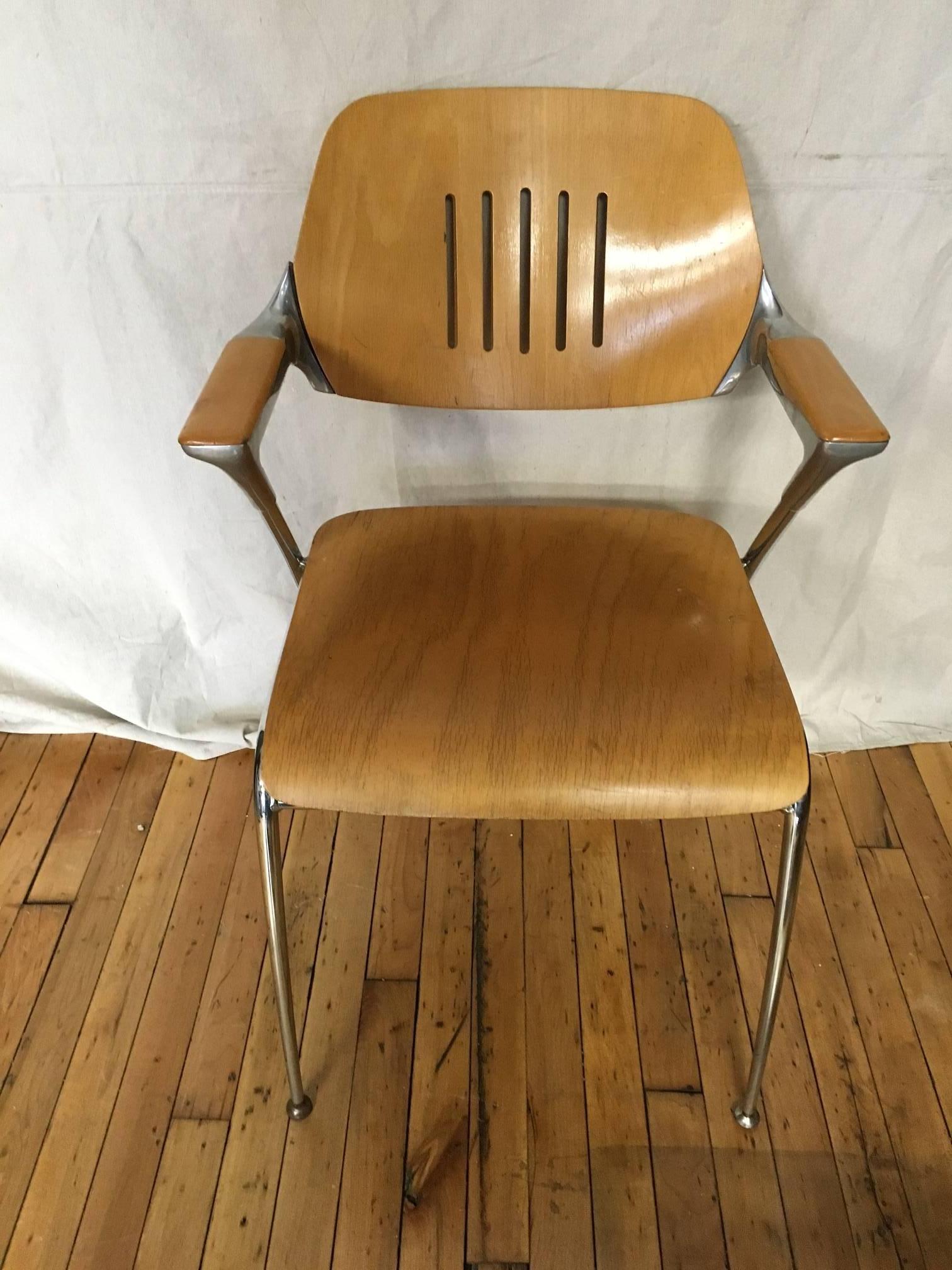 Thonet-style stacking chair is sturdily made of thick, varnished ply mounted on a steel frame. Excellent condition, extremely comfortable with curved seat, vented backrest and z-shaped wooden armrests. Stylish and substantial for every day dining or