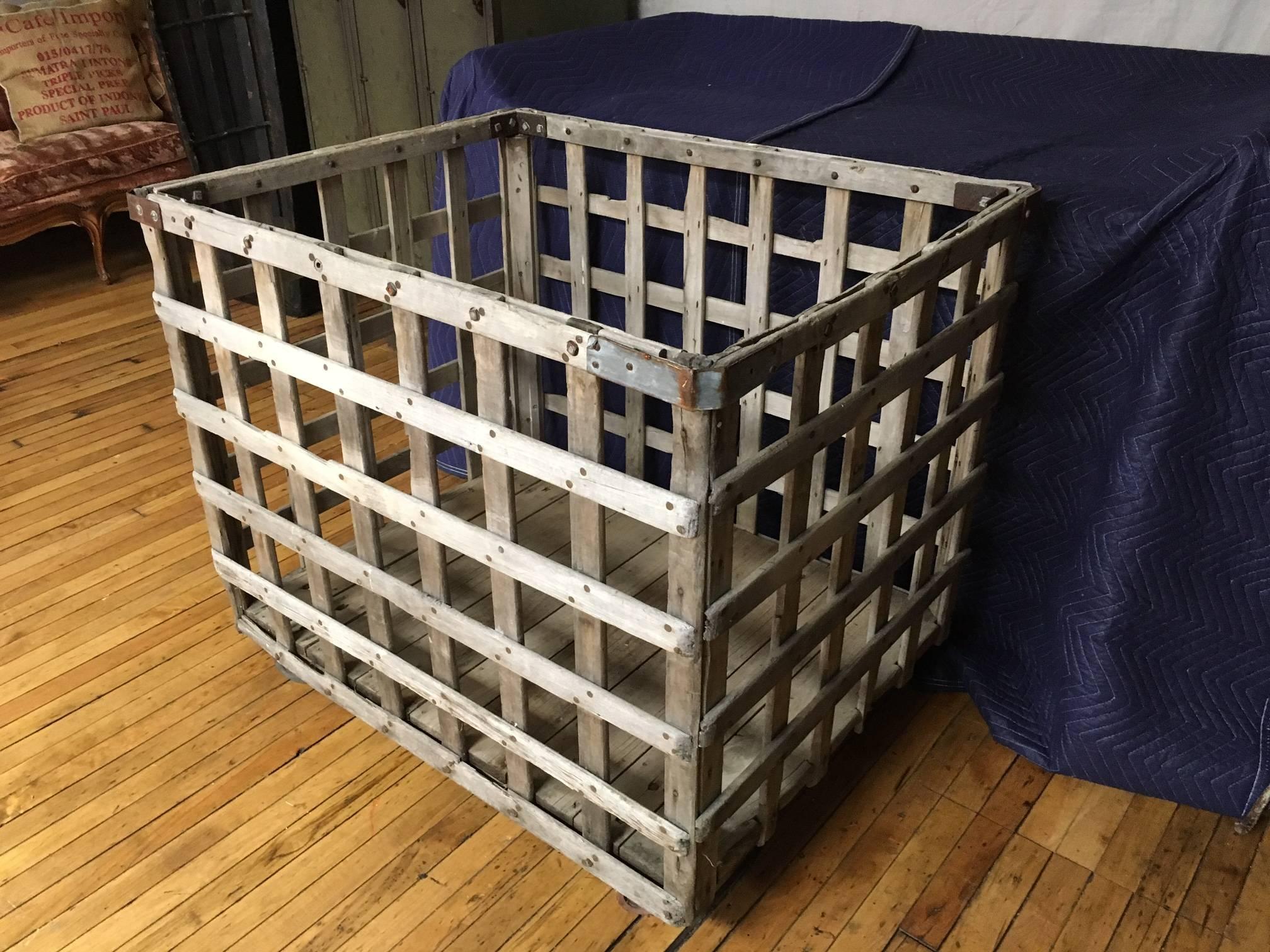 Industrial cart of wood with wheels. Built to take the punishment of the factory floor with reinforced steel corners, double-slat top and slat latticework horizontal and vertical. Wood slats are natural, nicely worn by work and weather and still