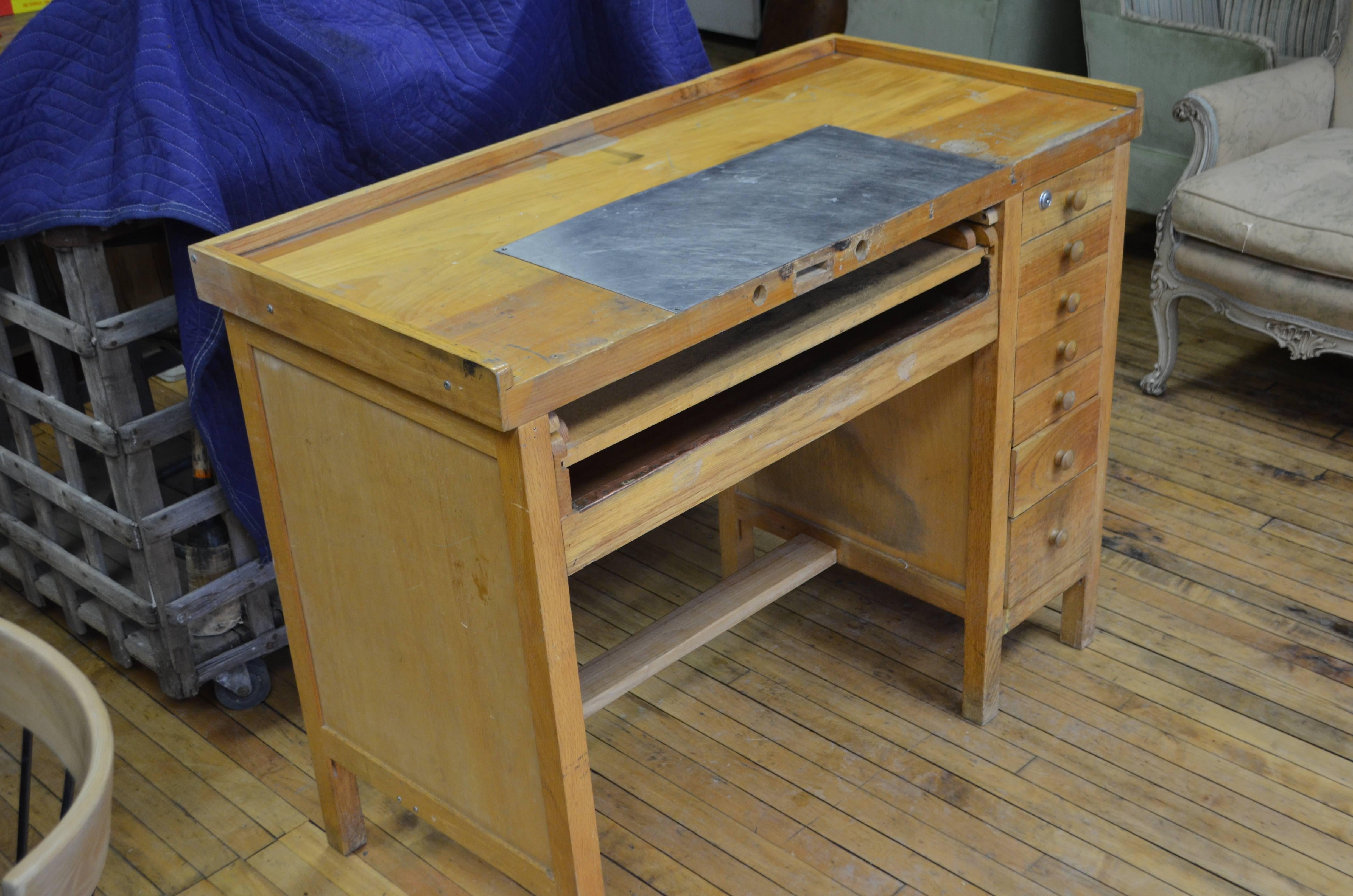 Mid-Century jeweler's workbench/desk complete with stainless steel cutting surface, copper-lined pull-out drawer, sorting tray and seven storage drawers on the side. Sturdily constructed from a mix of maple, pine and plywood on side and back panels.