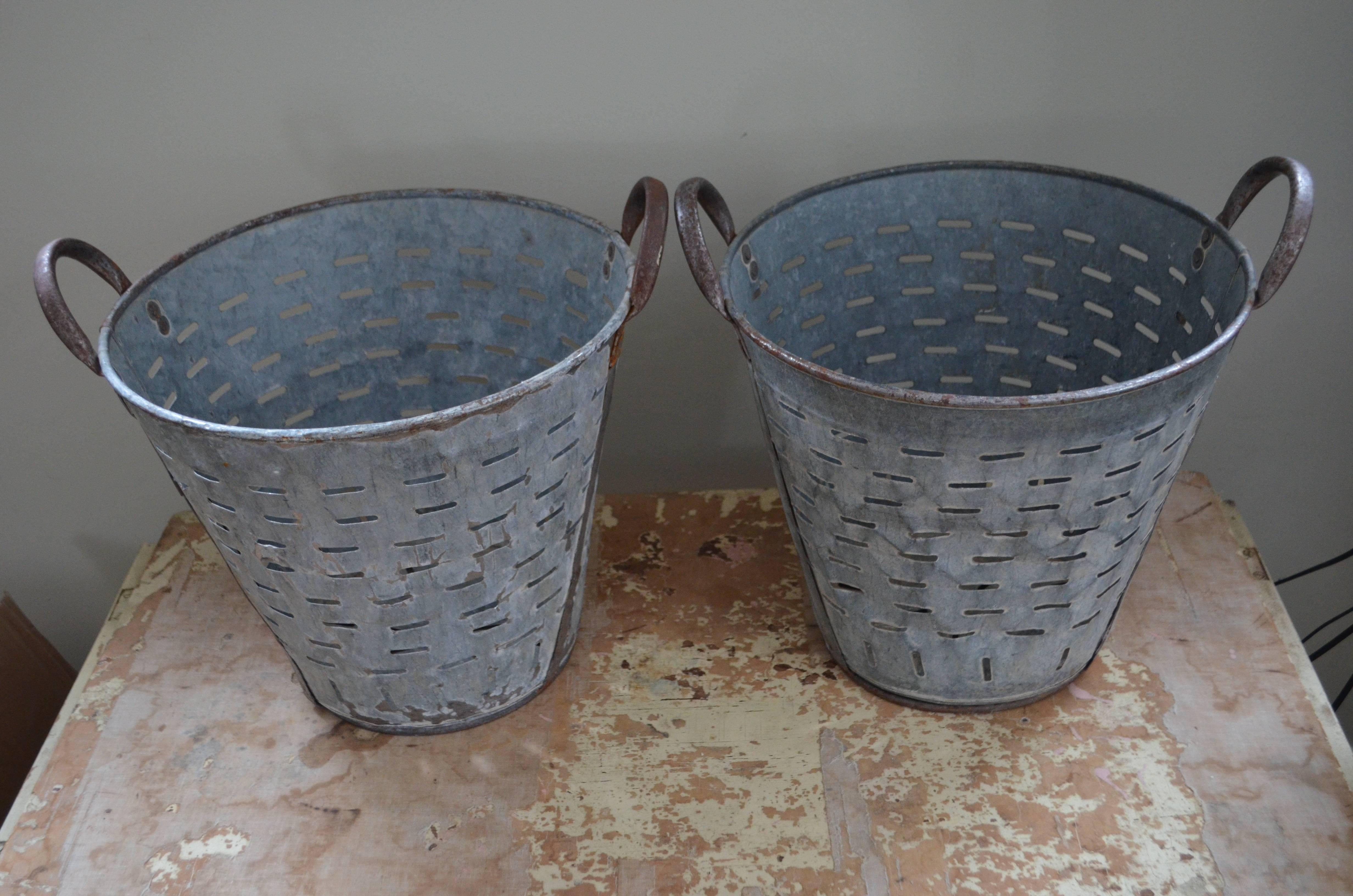 Pair of vintage Turkish galvanized steel baskets used to harvest olives. Vented to allow washing of the harvest. Their use in the home and garden are many fold: bathroom towels, magazines/newspapers, recycled paper, vegetable harvest, we've even