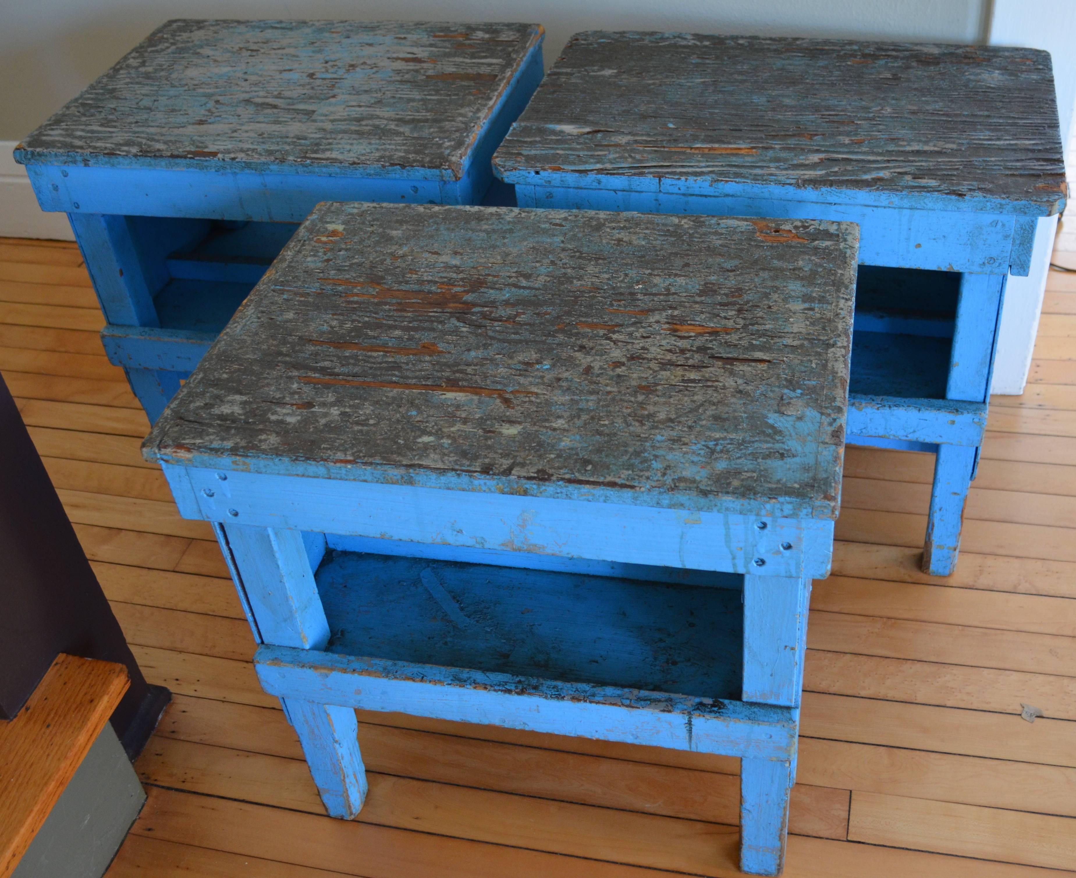 Industrial factory stand/workbenches, three in total, make versatile and striking end tables/sitting benches. Hail from a long-gone factory in Western Massachusetts. These benches were used on top of other larger benches for small parts assembly.