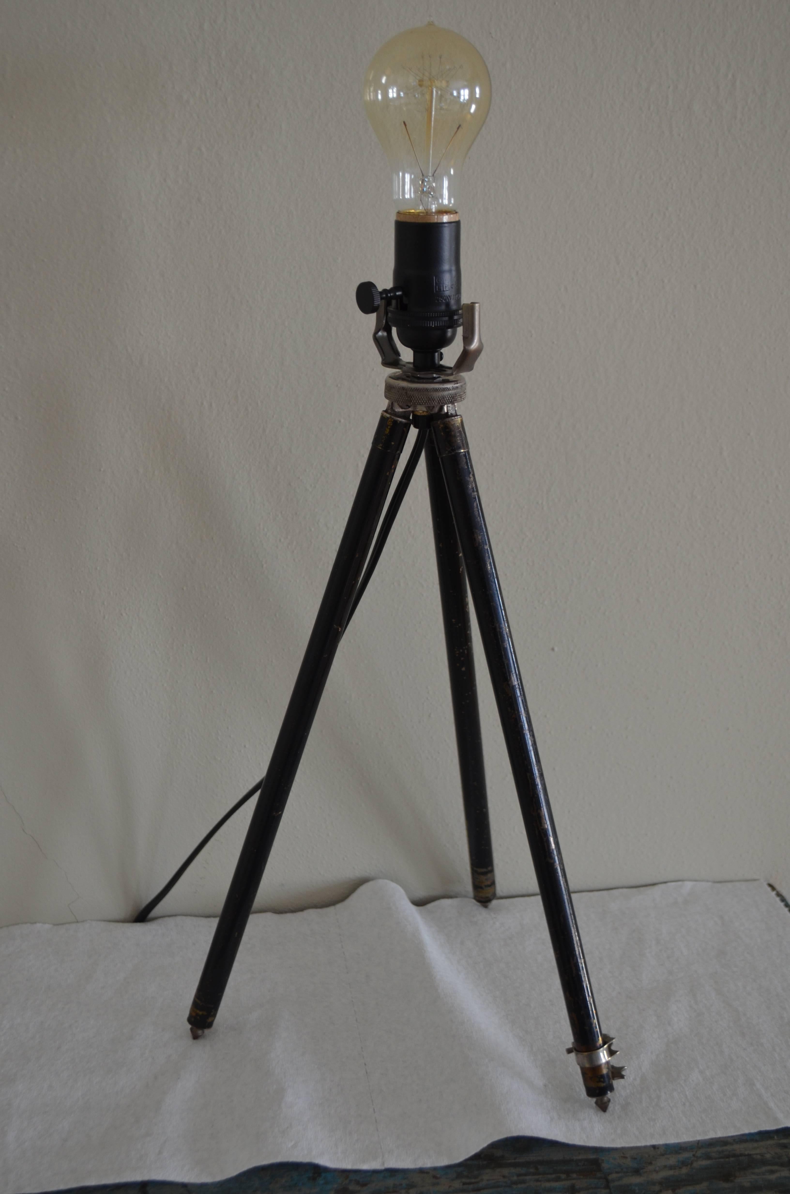 Lamp made from photographer's tripod functions as table lamp or floor lamp with legs fully extended. Table lamp size at smallest is 21" height x 8" diameter. Floor lamp size, fully extended, is 53" high by 22"diameter at bottom.