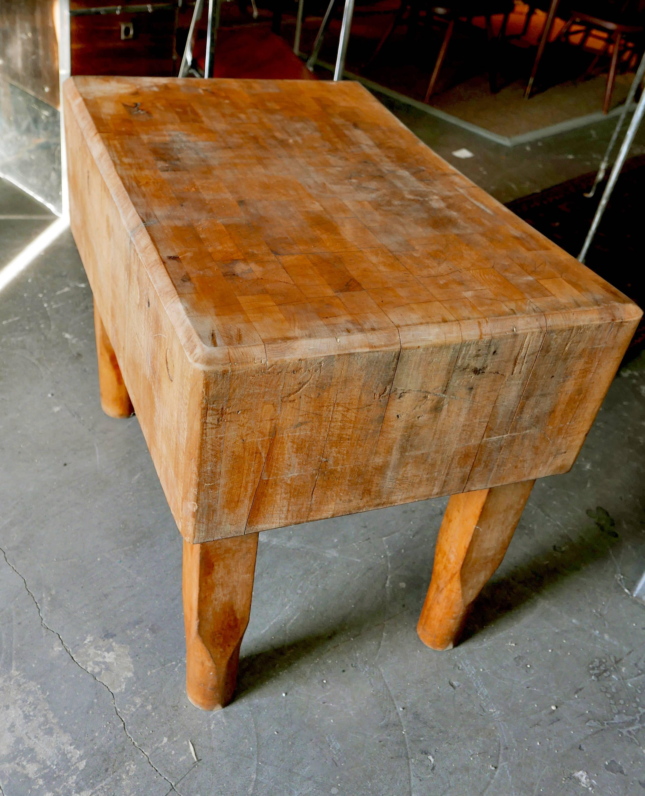 Butcher block from New York meat market dates back to the early 1900s. Rock solid maple with wonderfully patinaed surface from use and wear atop stout, carved out legs. You could dance on it. Put on wheels and raise it to island level. Remarkable