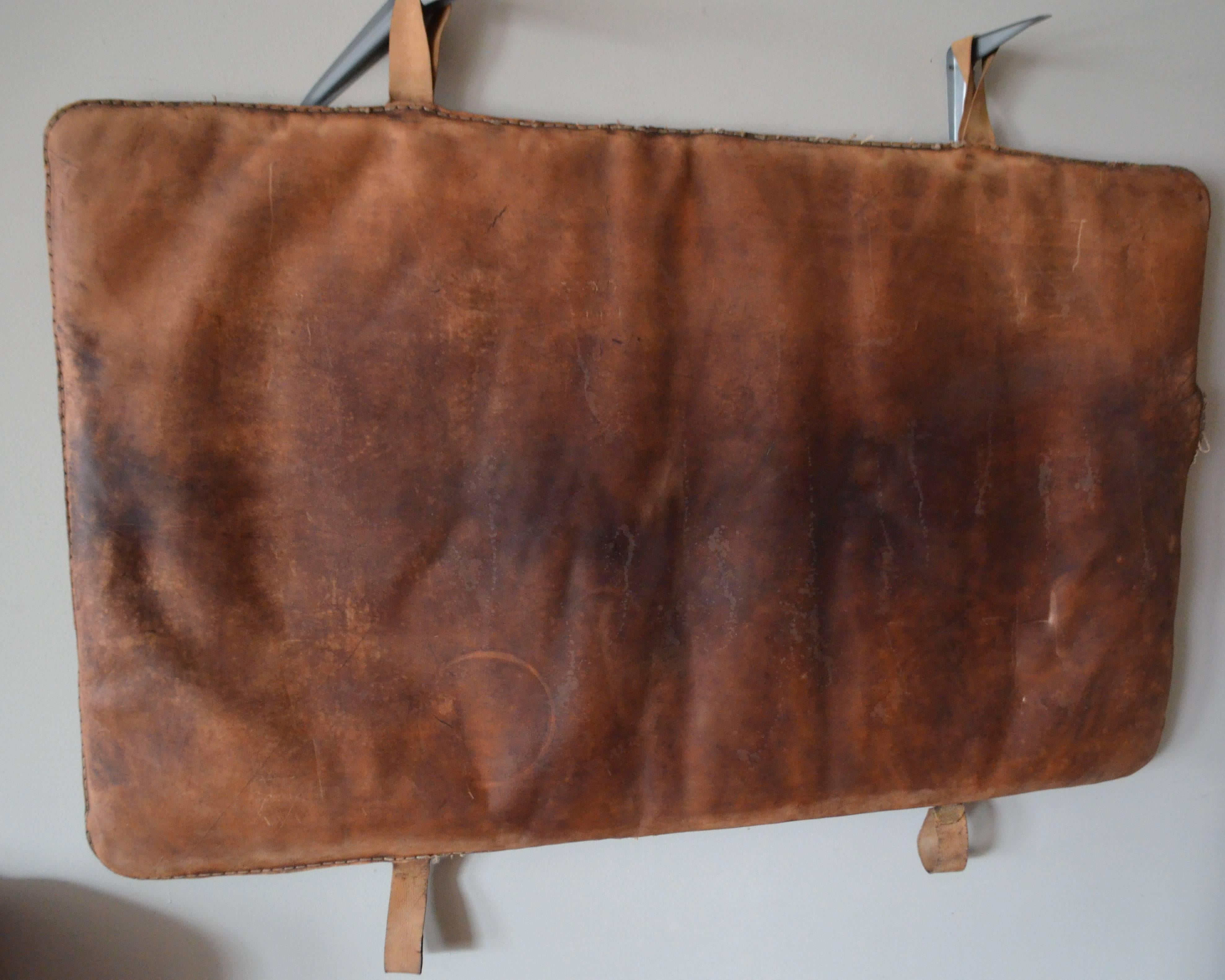 Gym mat of beautifully worn leather on both sides from Germany in the 1930s. Hanging straps are canvas. Has been thoroughly cleaned and conditioned. Art for the wall, coffee-tabletop, headboard.
