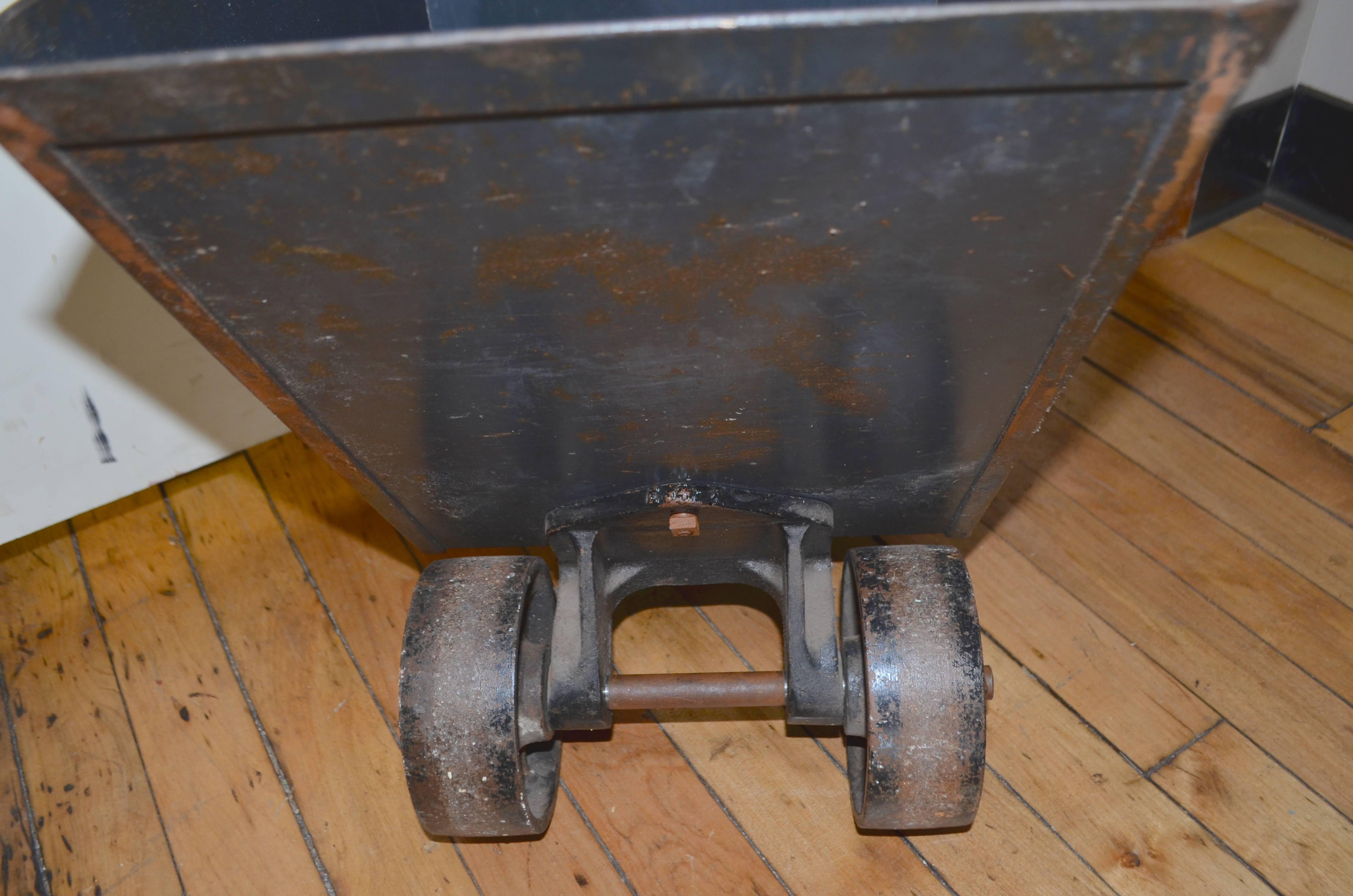 Coal cart of steel on heavy duty steel wheels with handle makes an ideal mobile planter. Roll it effortlessly from house to porch to deck to yard. Wheel beneath handle pivots for easy maneuverability. Rock solid with wonderful blue sheen on the