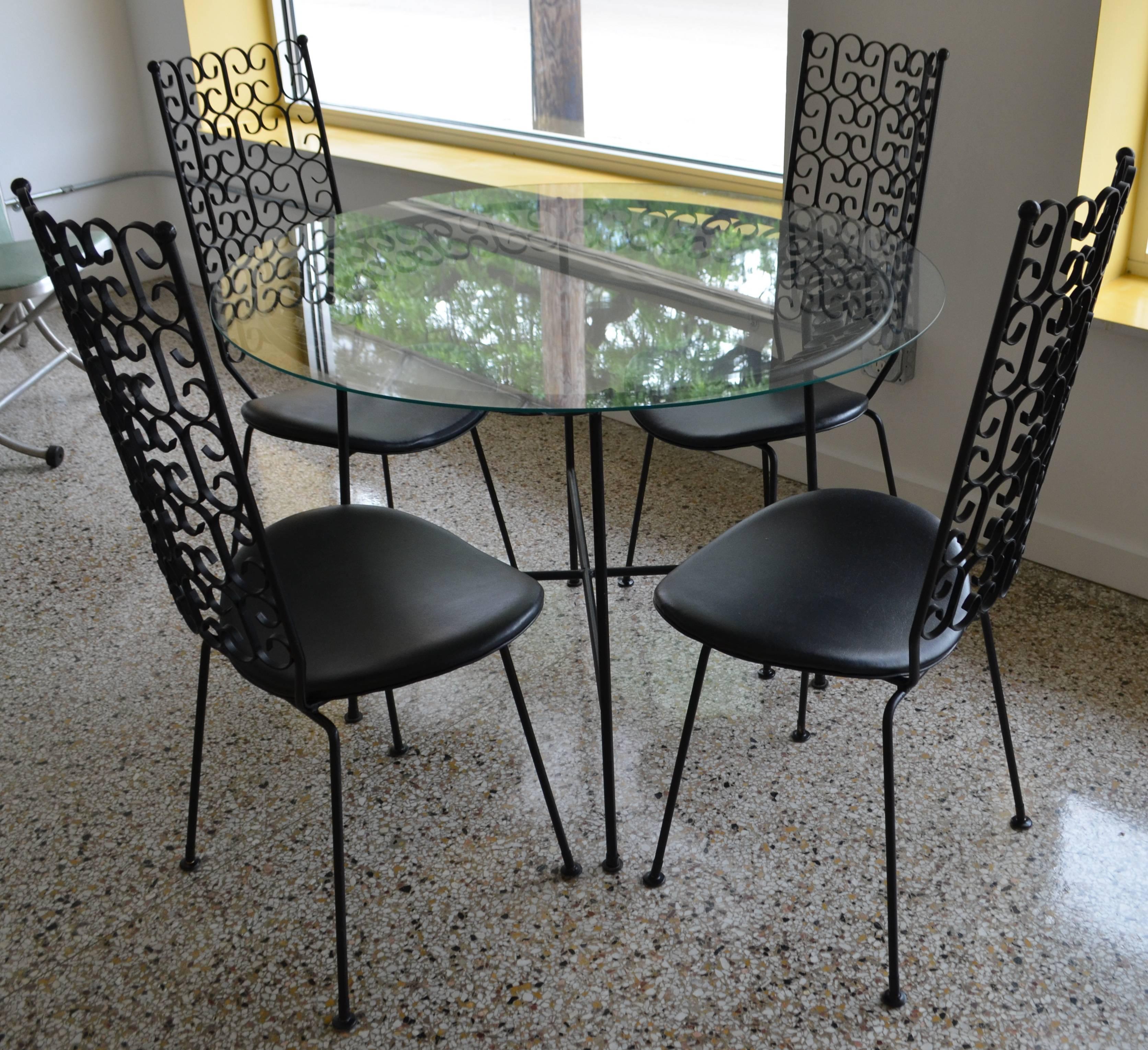 Arthur Umanoff wrought iron patio set of table and four chairs from The Grenada collection. Each chair measures: 16.5 inches D x 18.5 inches W x 40.5 inches H. Floor to seat is 18 inches. Table dimensions noted below.