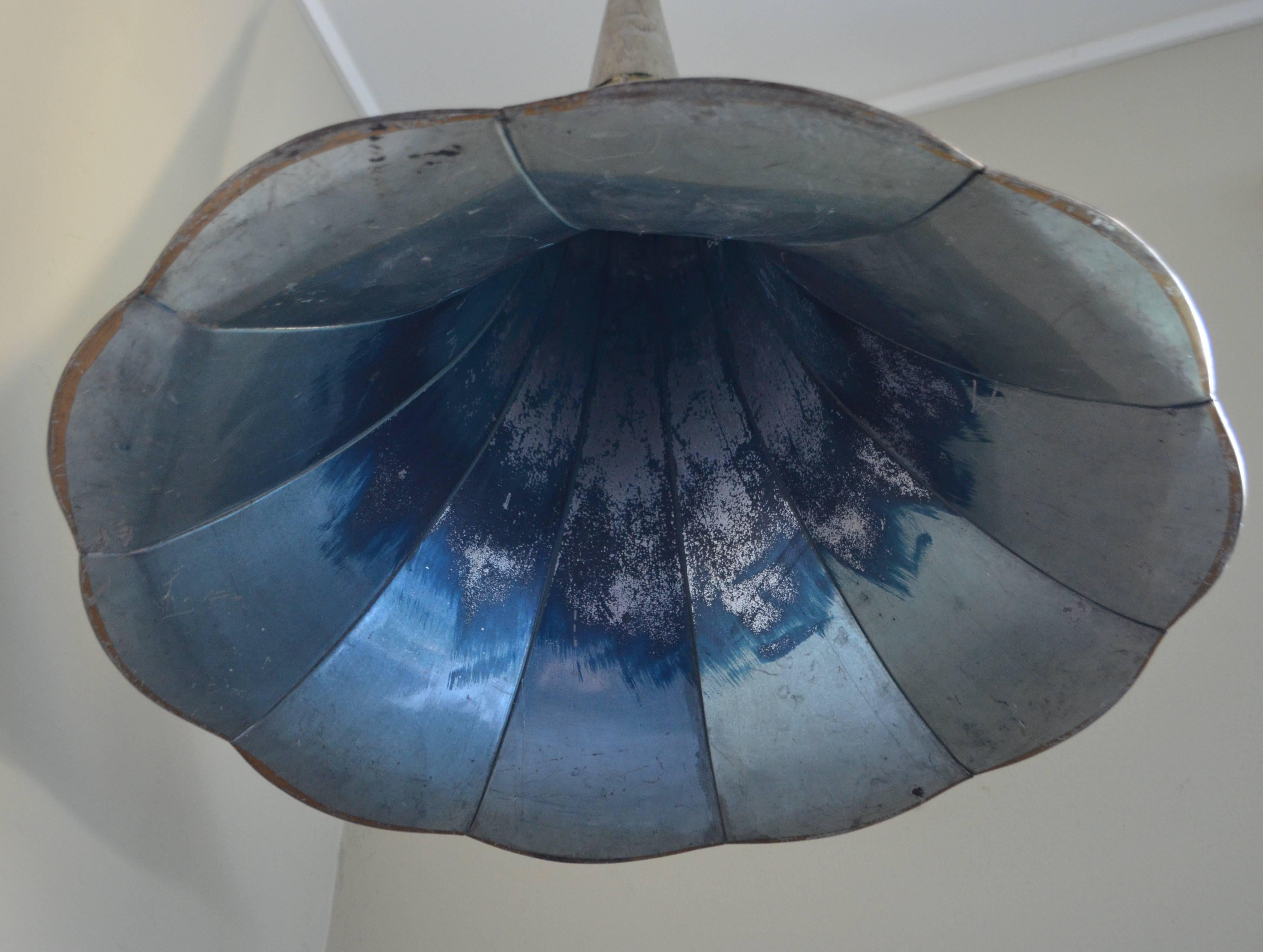 Pendant light has been made from an antique gramophone Horn. Silver outside with nuances of blue inside. Professionally wired with grounded porcelain socket and black pendant wire. Includes modern steel ceiling canopy and strain relief for wiring