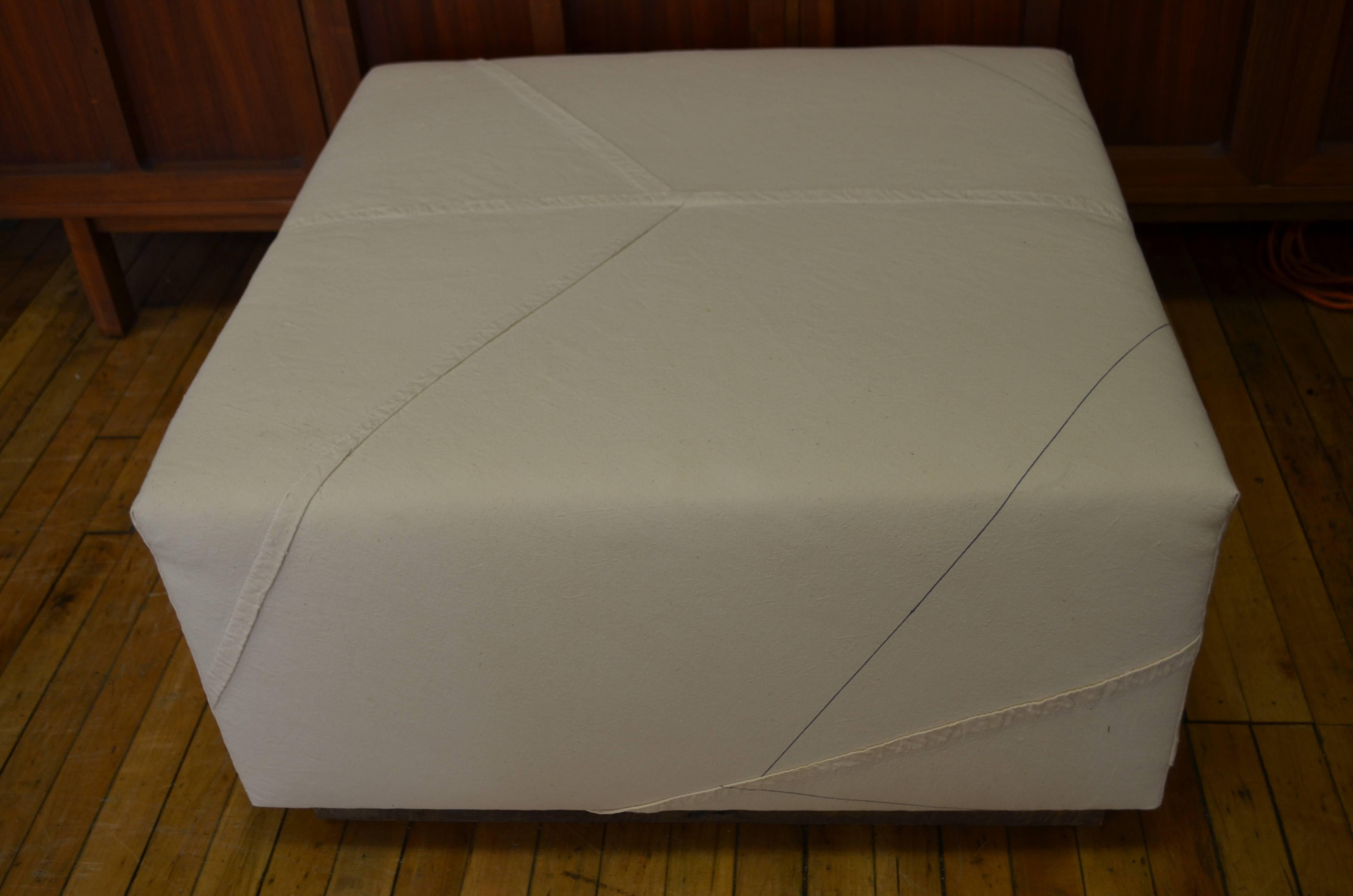 Ottoman upholstered in World War II British cargo parachute mounted on a barn board base. Newly upholstered by a Parisian-trained upholsterer, this piece combines an historical icon with a subtle and sophisticated design presence and function. As