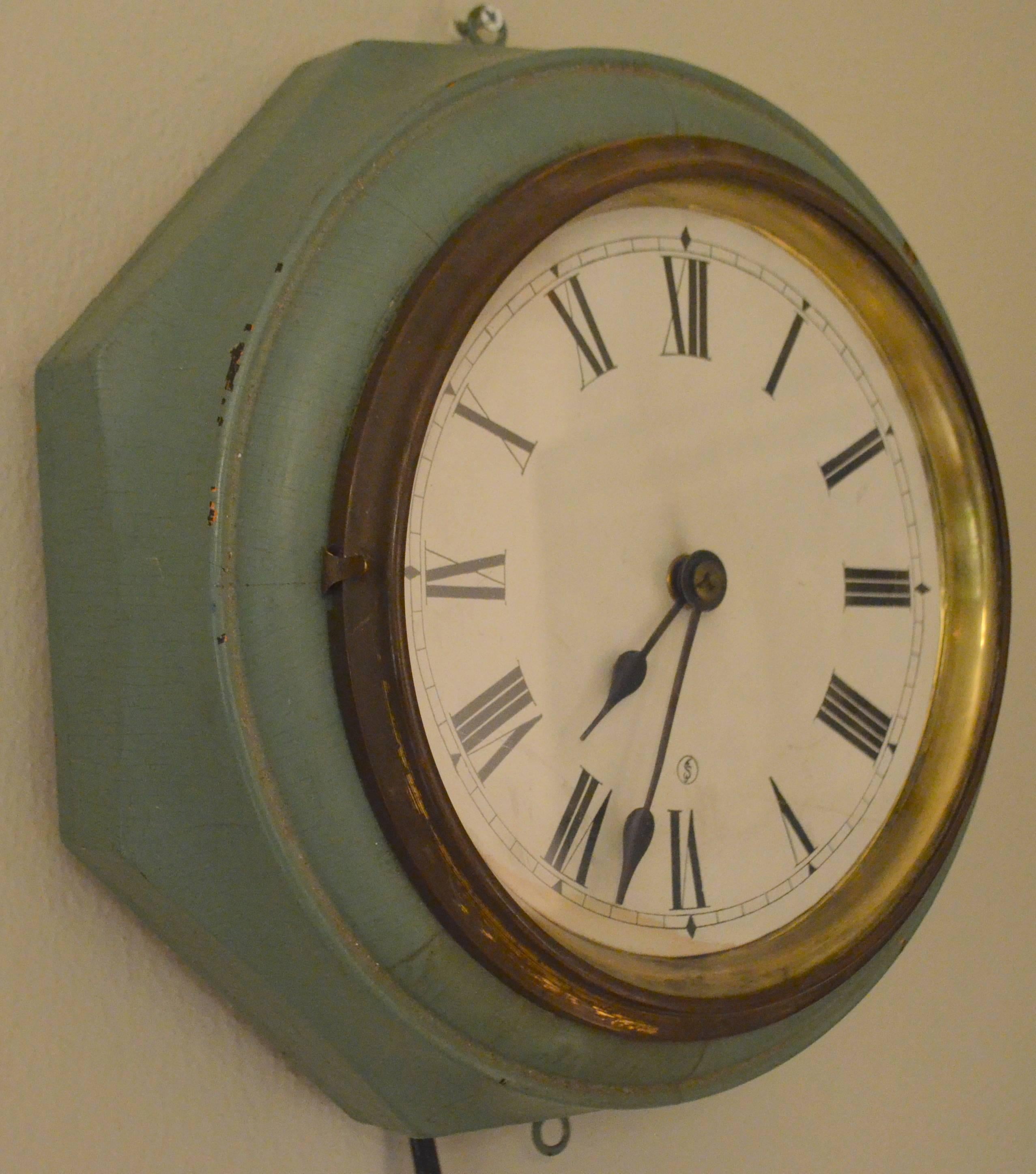 Wooden electric wall clock from the early 1900s with Roman numerals. Glass front framed in brass, hinges out for adjusting time. Keeps perfect time. Note the wooden housing: circular within an octagon.