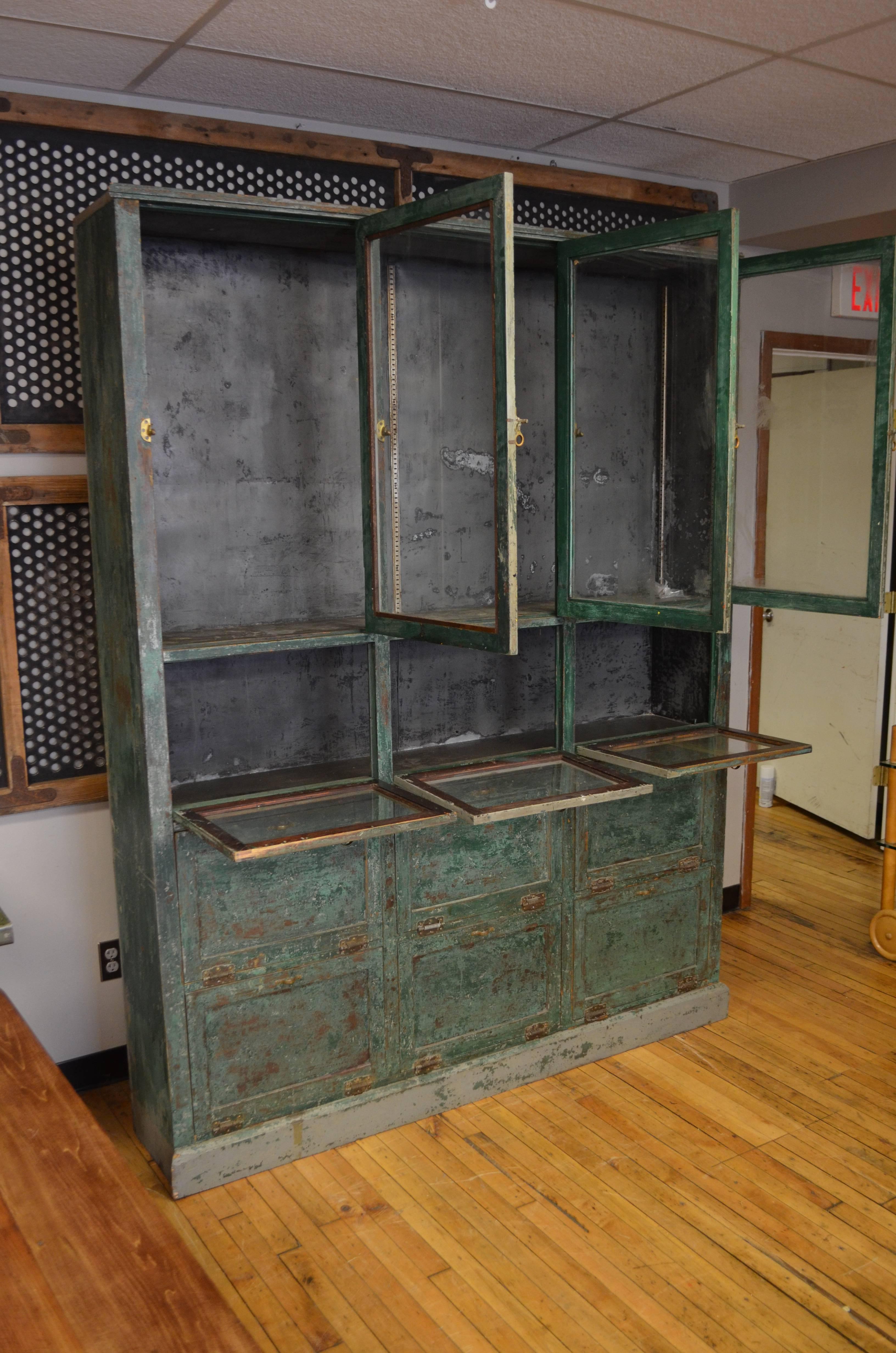 Storage cabinet and cupboard is from the late 1800s. Was used as a humidor in small town pharmacy in the Midwest. Beautifully constructed with original glass on doors, spring loaded hinges on cupboard doors. Lined with zinc inside to preserved