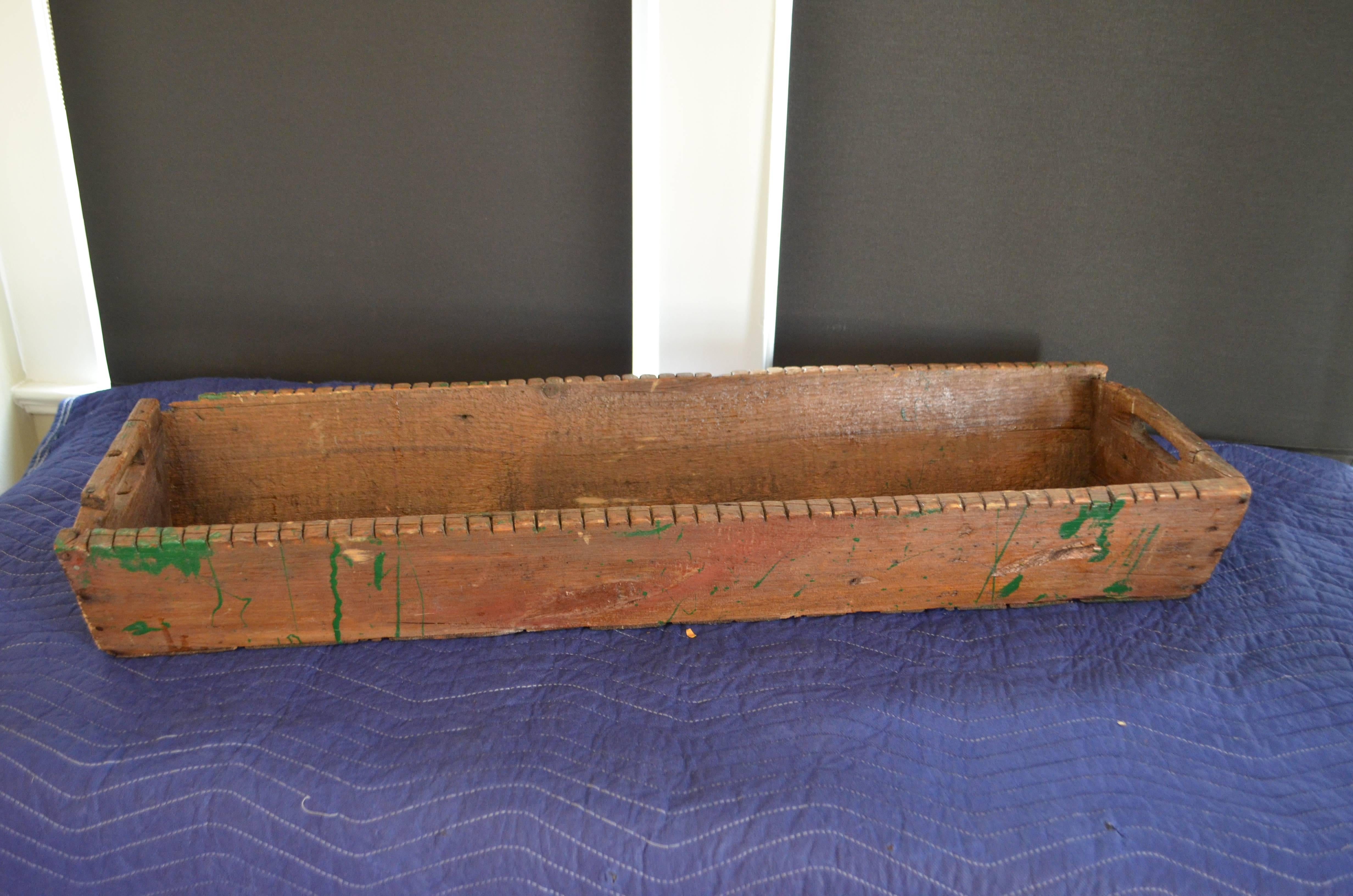 Table centerpiece display from Primitive line-setter box for catching catfish on the Mississippi. Handmade and dating back to the 1800s. Splashes of paint highlight the patina of wear and use. Note the slash cuts in the wooden sides of the box for