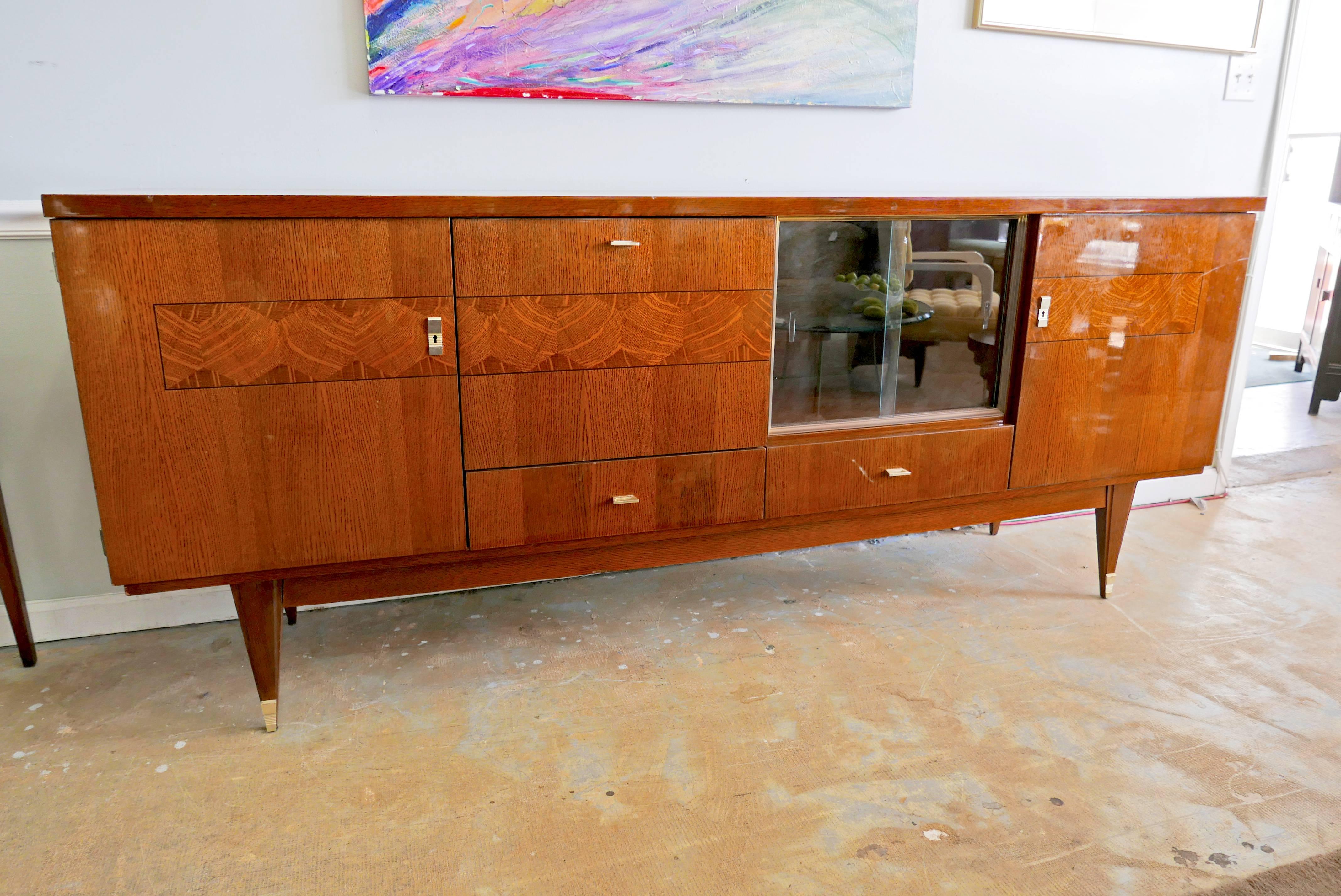 Art Deco credenza from France, circa 1930s. A glorious, glamorous heirloom piece with wonderfully detailed facade and hardware. Cabinet door drops down on hinges, other cabinet has double glass doors. Voluminous storage capacity. An entertainment