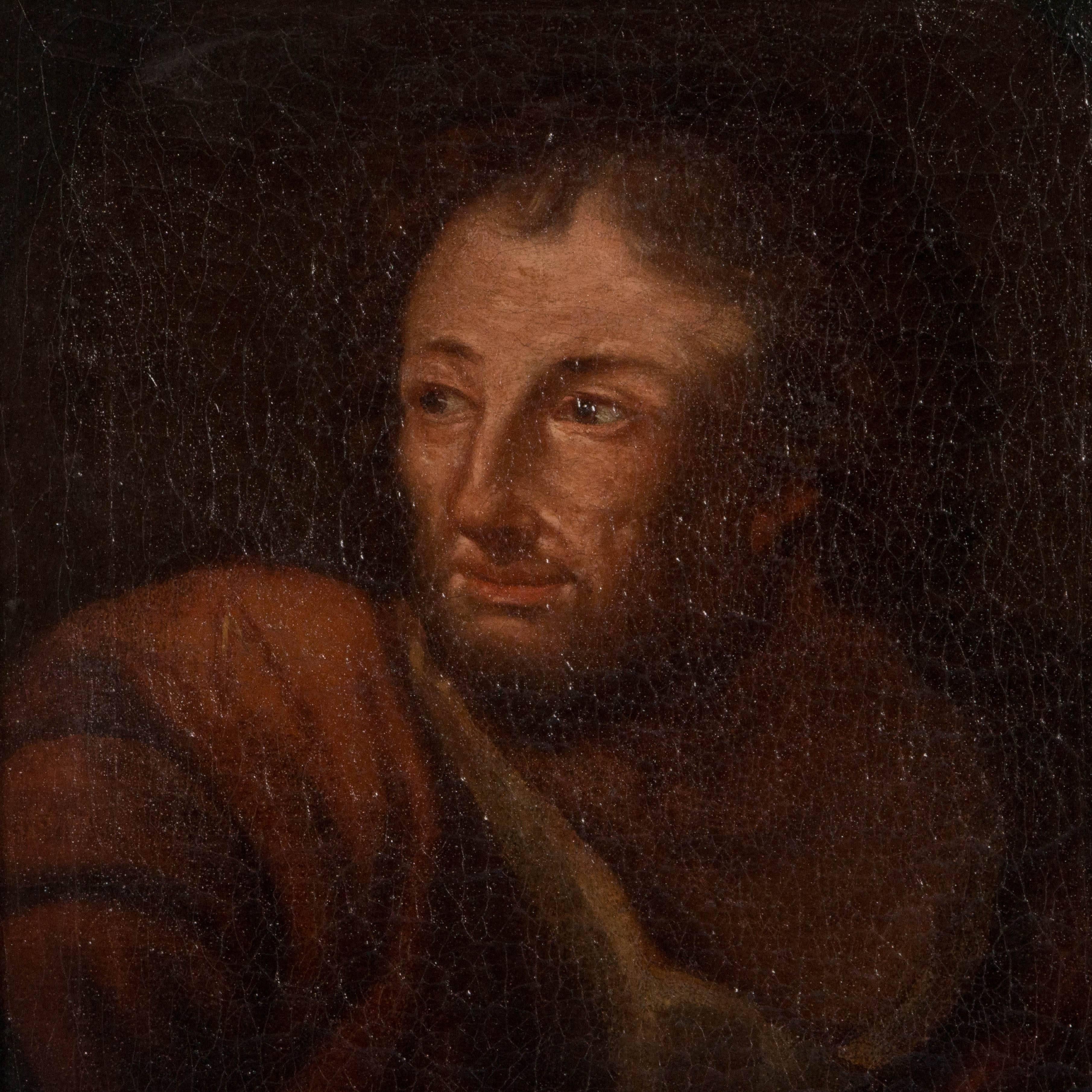 An unsigned late 18th or early 19th century antique oil painting portrait of a bearded man in robes. The painting is in the style of the Italian school with craquelure throughout the canvas which is mounted in a giltwood frame. There is a small