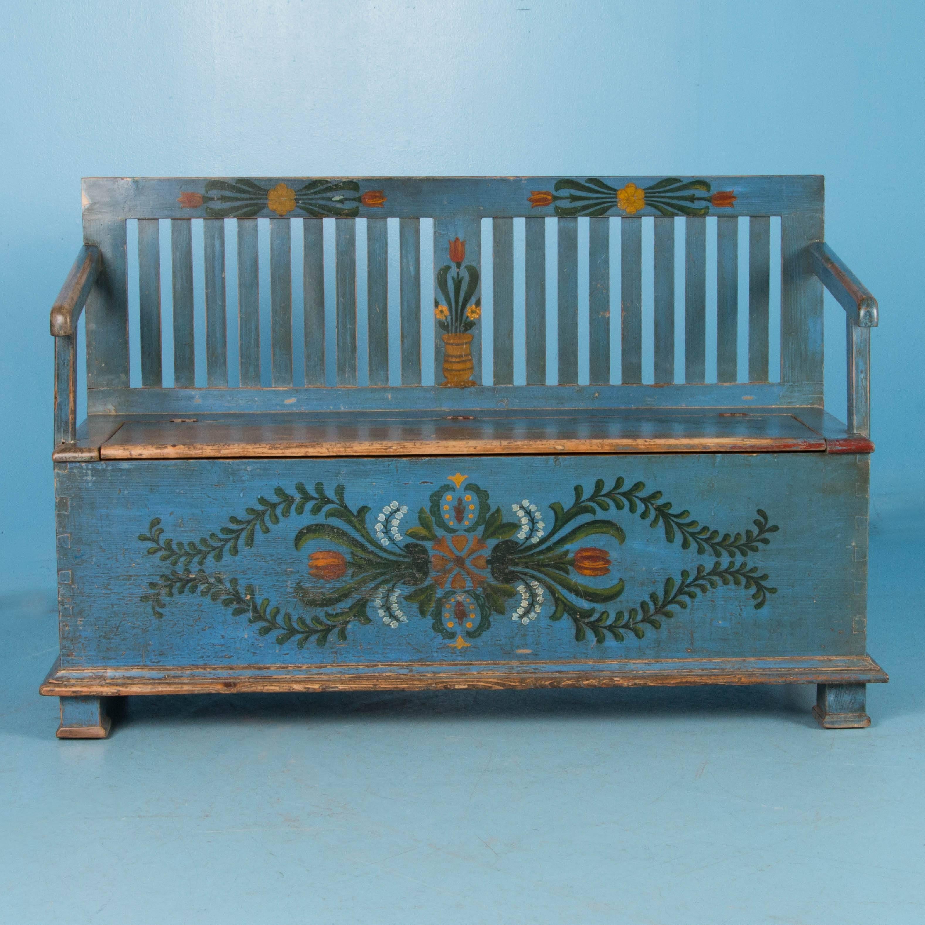 This delightful cottage style storage bench still maintains its original paint, with a traditional green, yellow and red floral and vine design on a light blue background. It is a perfect size for an entry at just under 5 feet long, and still has