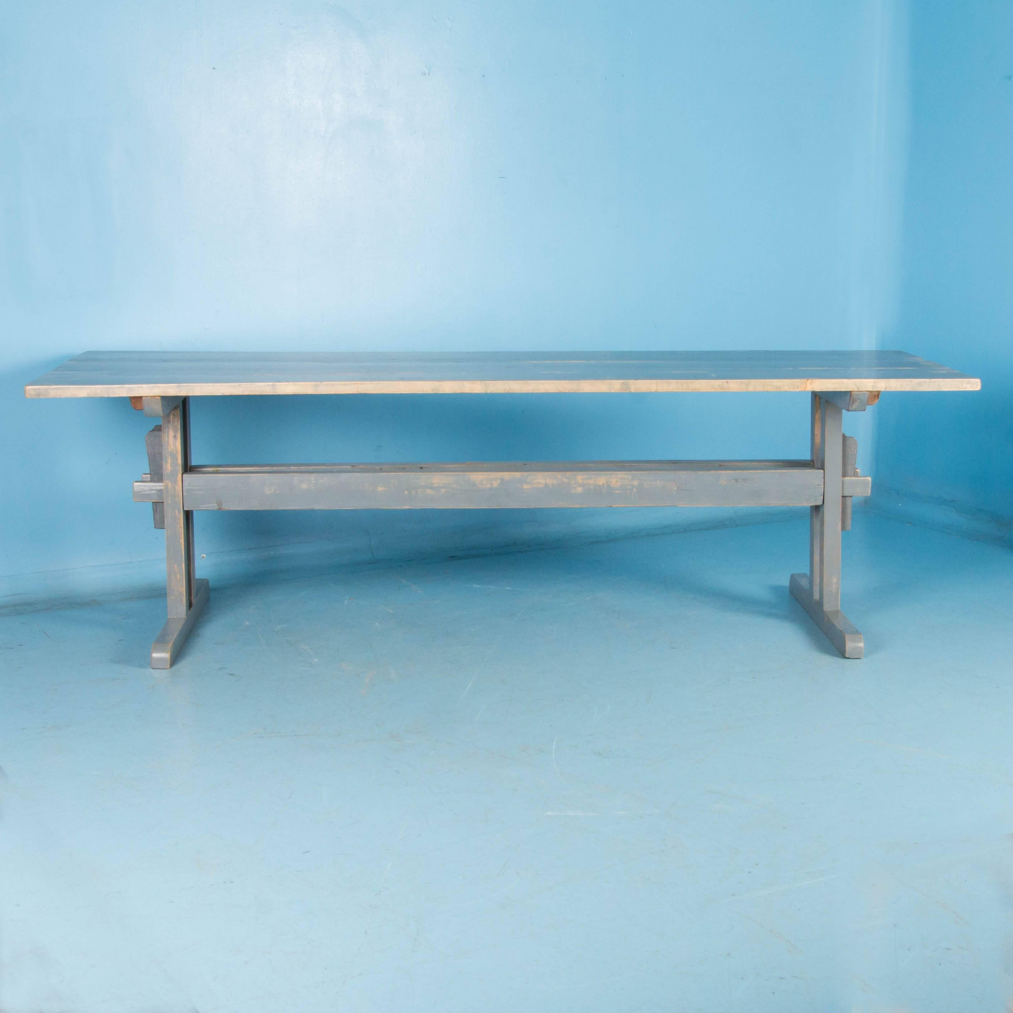 While pine trestle tables were traditional and found throughout the European countryside in the mid to late 19th century, it is unusual to find one that still maintains its original paint as this one does. The soft dove gray paint has worn away in