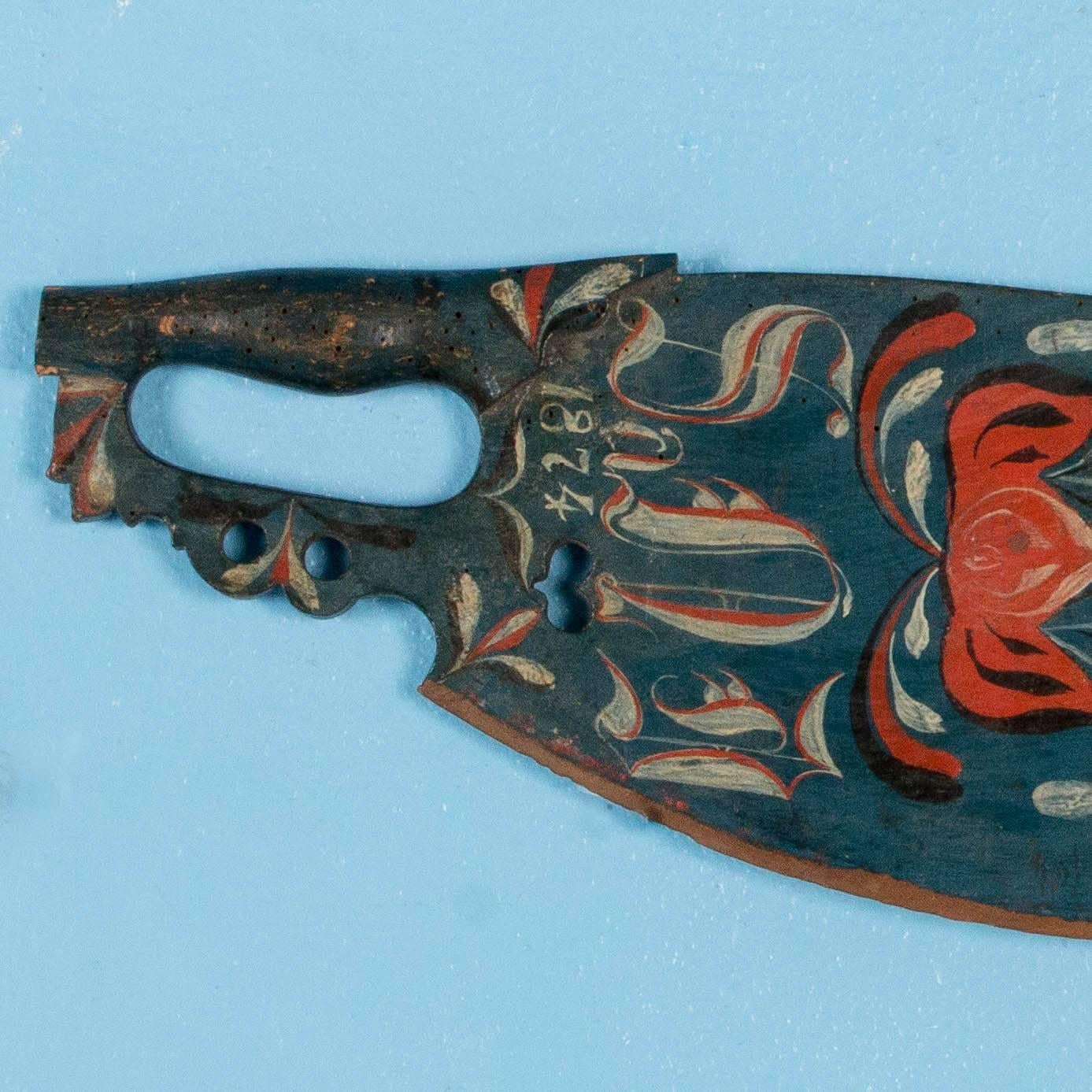 This hand-carved skaktetra was traditionally given away as a bridal gift, usually with beautiful painted decorations and often dated. This one has the date 1874 with a red and green floral decoration on a deep blue background. Originally these were