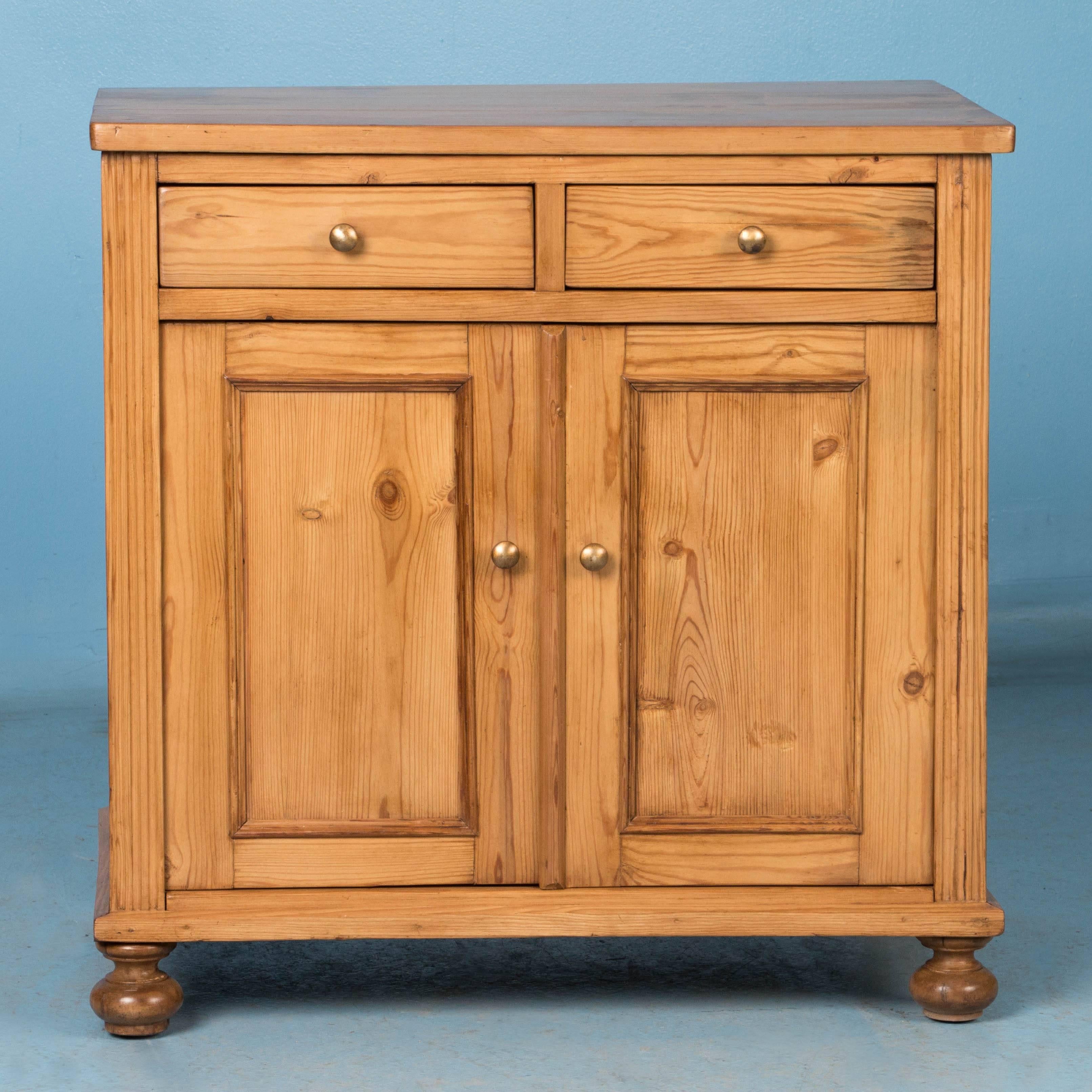 This European country sideboard was crafted around 1890 in Denmark and features simple lines and paneled cabinet doors with traditional bun feet in front. It has been completely restored and is strong, functional and ready for use while the wax