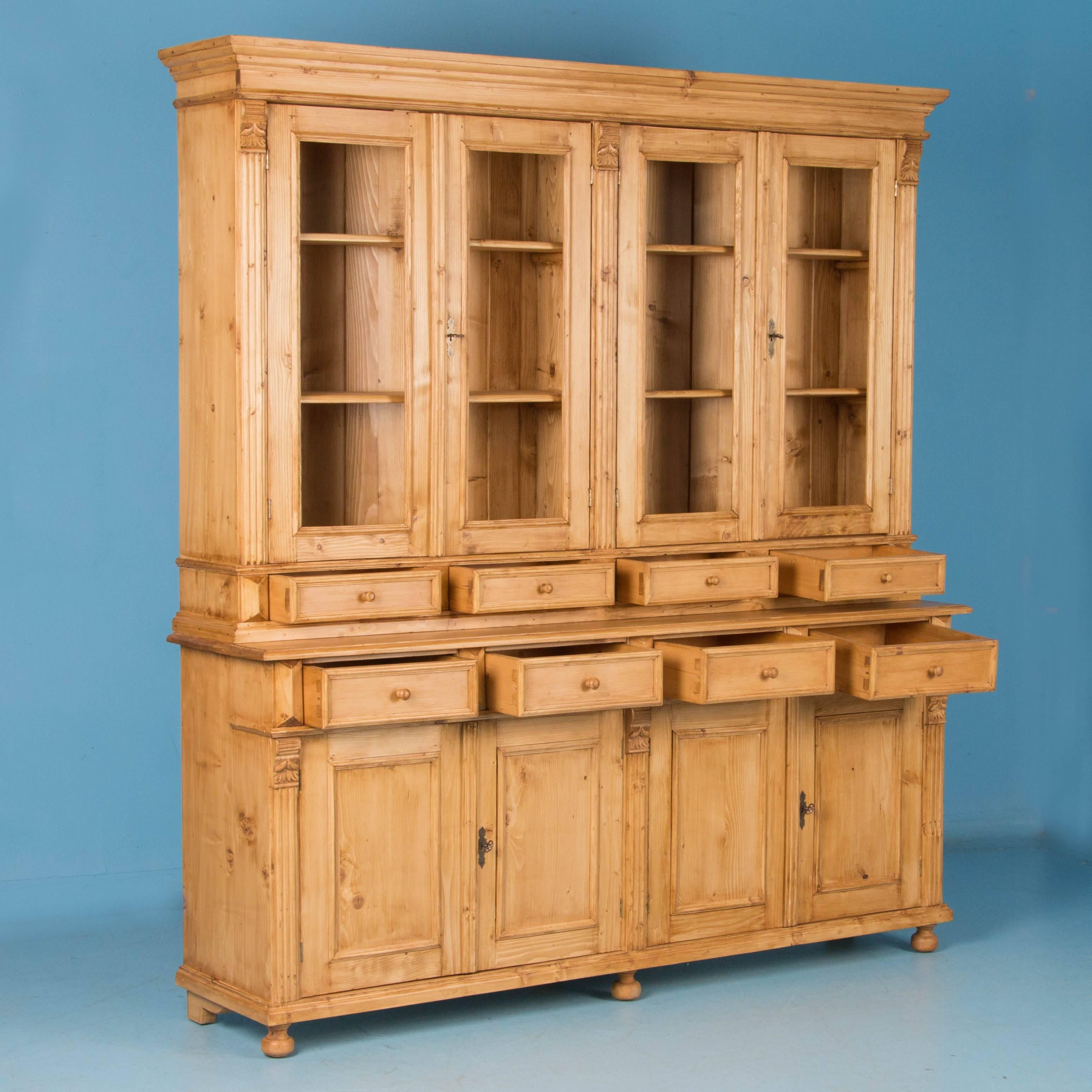 This large pine bookcase or cupboard is a replica, true to form, function and beauty of antique store display counters or grocers desks of the late 1800's. Built in two sections for easier assembly and moving, there are four hinged doors with four