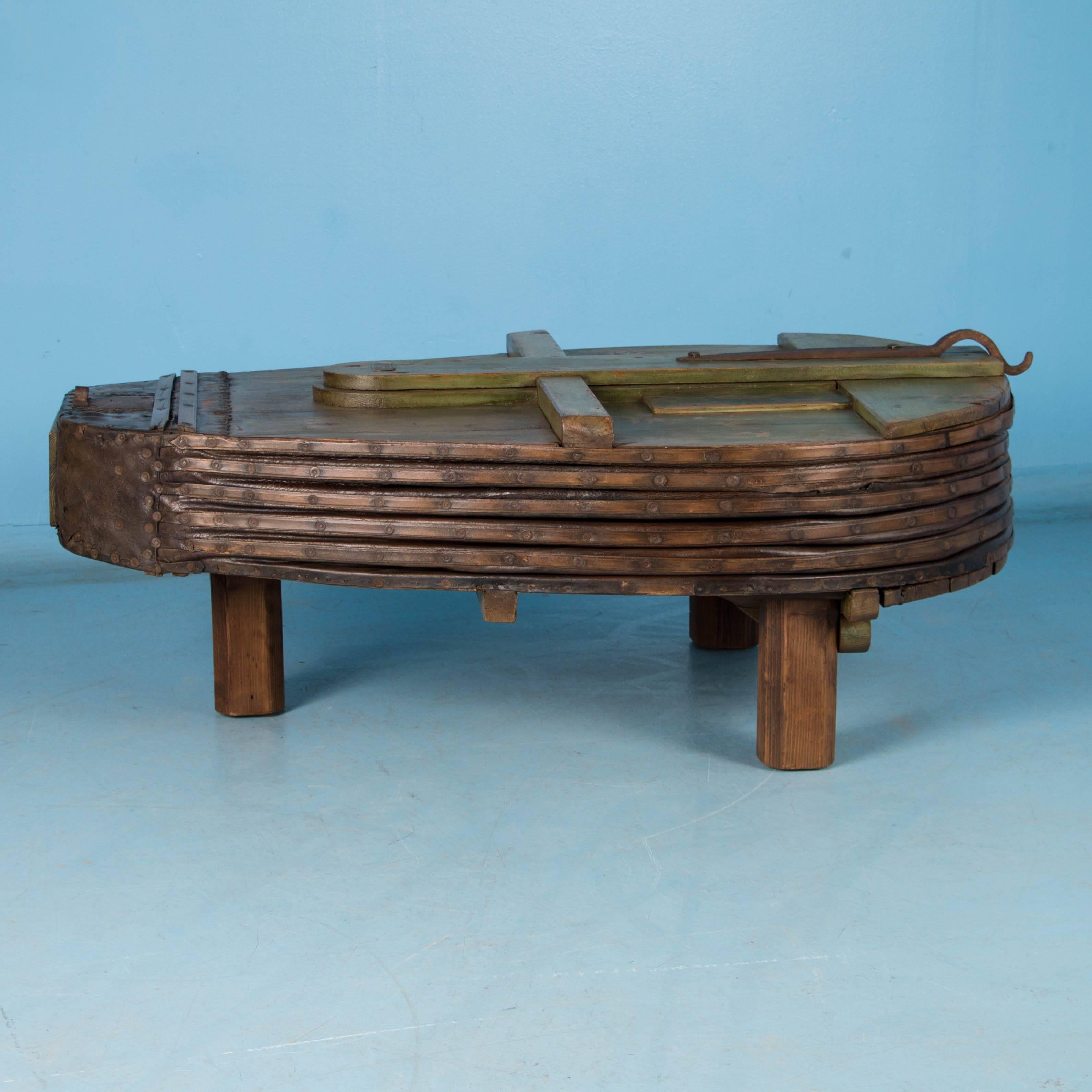 This highly unusual coffee table is made from an original antique blacksmith's bellows, and even more interesting with the original green paint still intact. It has been placed on three feet so is stable, strong and level, ready for daily use. The