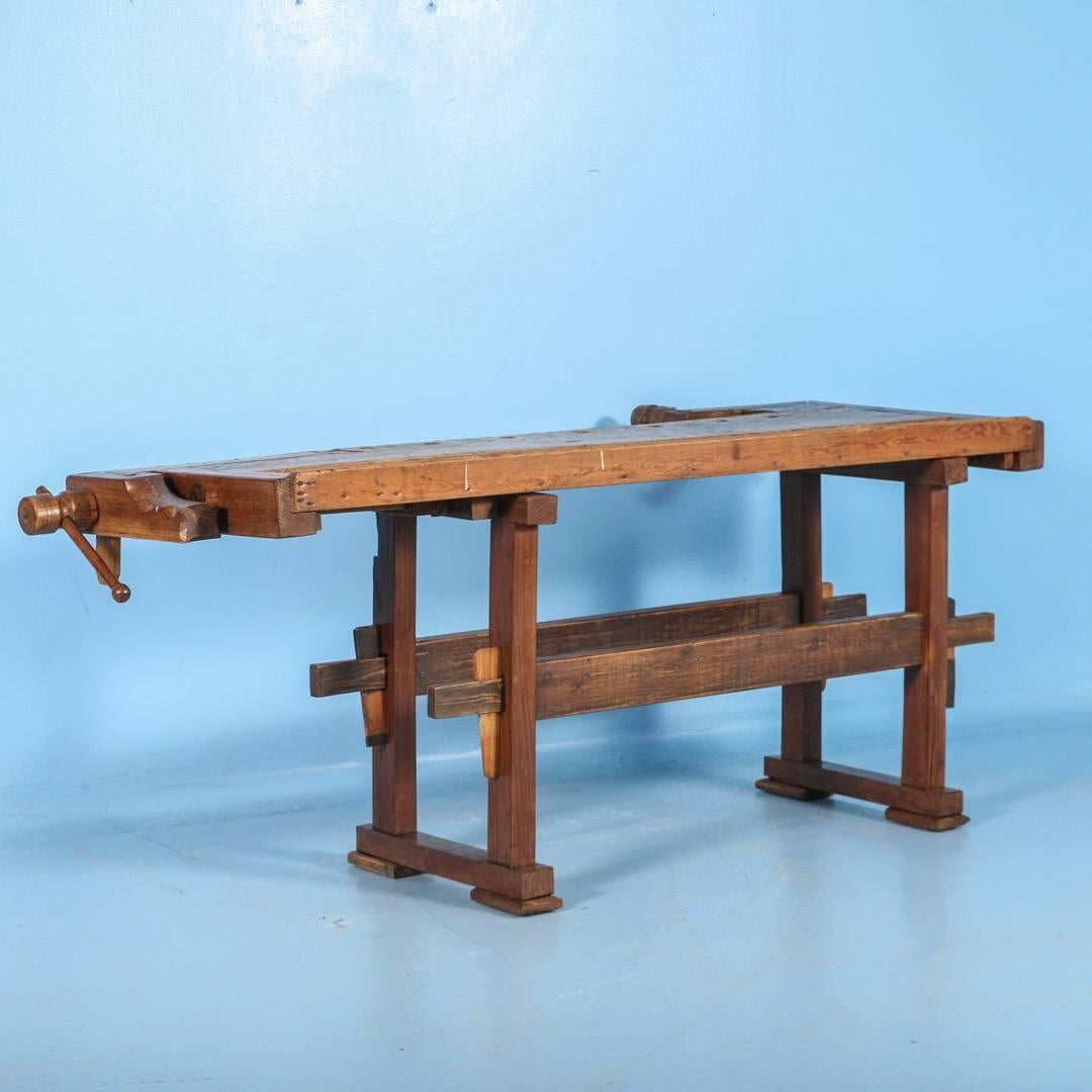 The depth of patina on this workbench comes from years of constant use. It has two wooden vices and a recessed tray where the carpenter would lay his tools. The upper left top has two metal bands that likely held a tool as well. The traditional