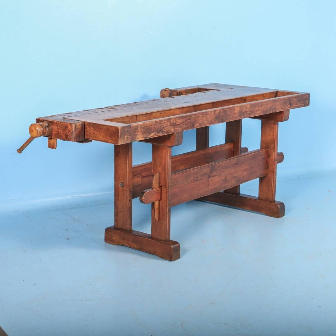 The rich patina on this workbench comes from the years of constant use by a carpenter. Please examine the close up photos to appreciate the depth of the patina. It has two wood vices and a recessed tray where the carpenter would lay his tools. The