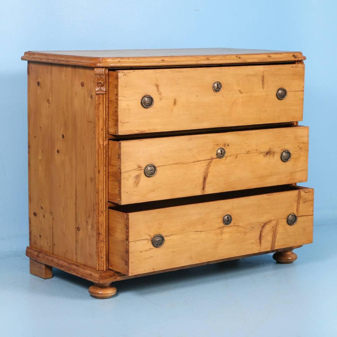 The beauty of this large chest of 3 drawers is the simplicity of the lines and large, spacious drawers. The simple carved detail along the sides were a traditional style element of the period.  The pine is waxed, bringing out the warmth of the wood