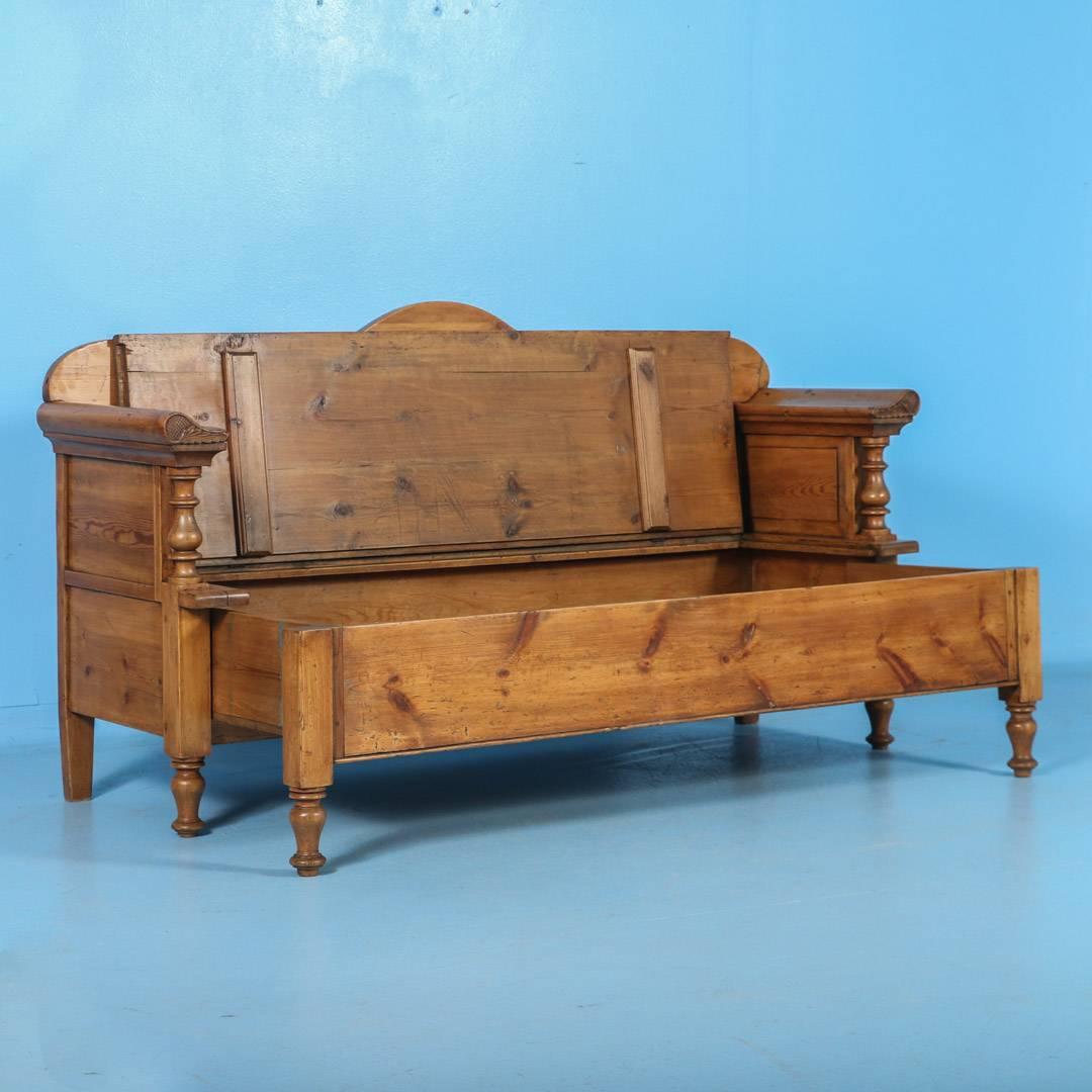 The deep, warm patina of the pine in this bench comes from over 100 years of use. Notice in the close up photos the turned columns and detailed carving at the end of the curved arm rests. This bench was originally designed as a type of 