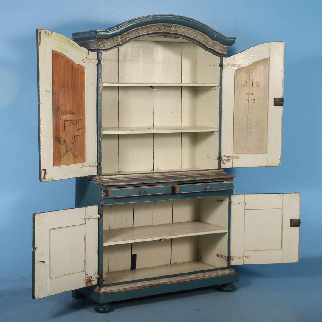 The soft blue and floral painted motif are delightful in this exquisite Swedish Cupboard. Inner top shelf originally served as a spoon rack, while the inside doors with dates reveal a story to tell. You will notice the date of 1792 in three