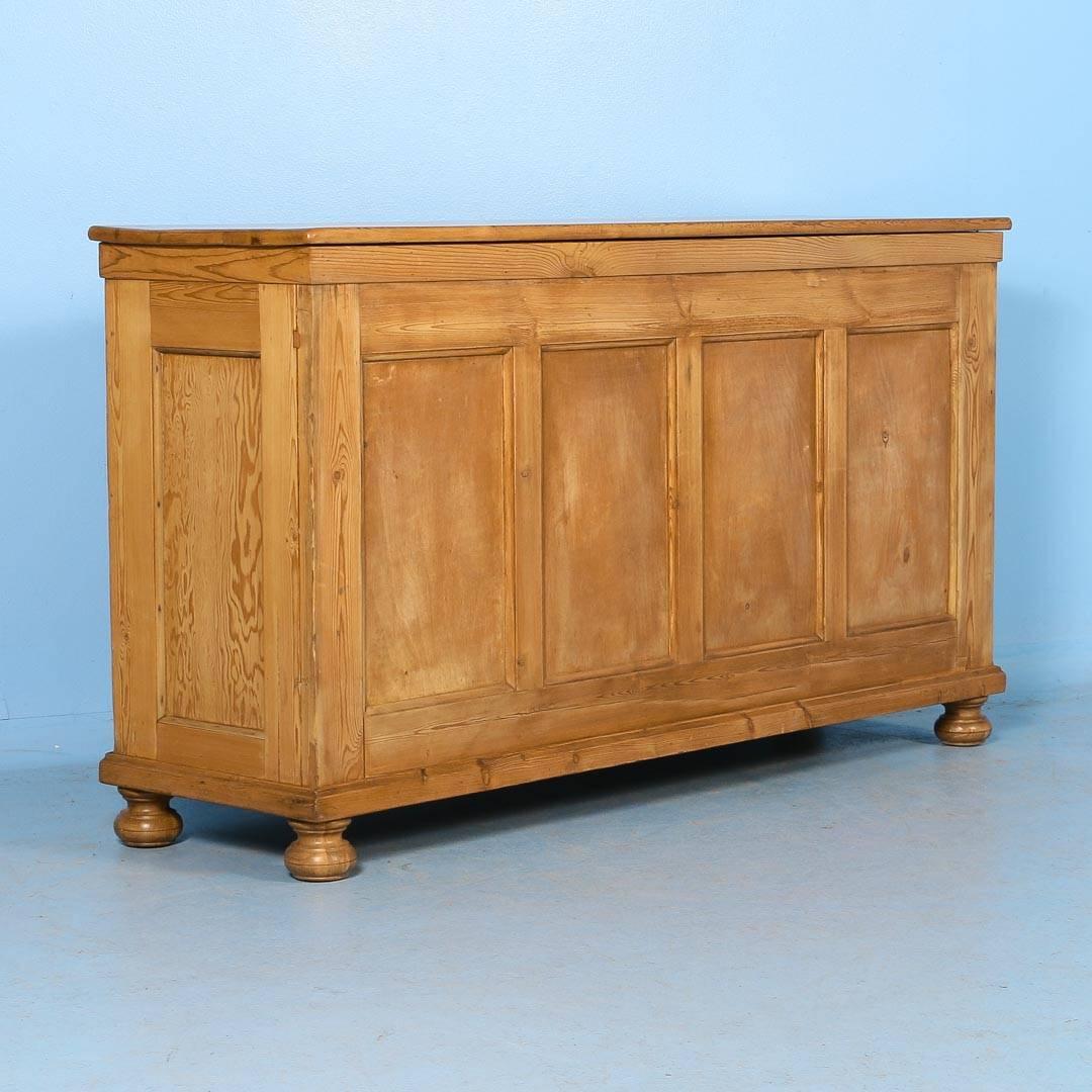 This Danish pine grocer's counter has nine drawers, graduating in size from top to bottom, with paneled sides and back. Professionally restored and waxed, the cabinet is tight and all the drawers are working well. As a sideboard or a kitchen island,