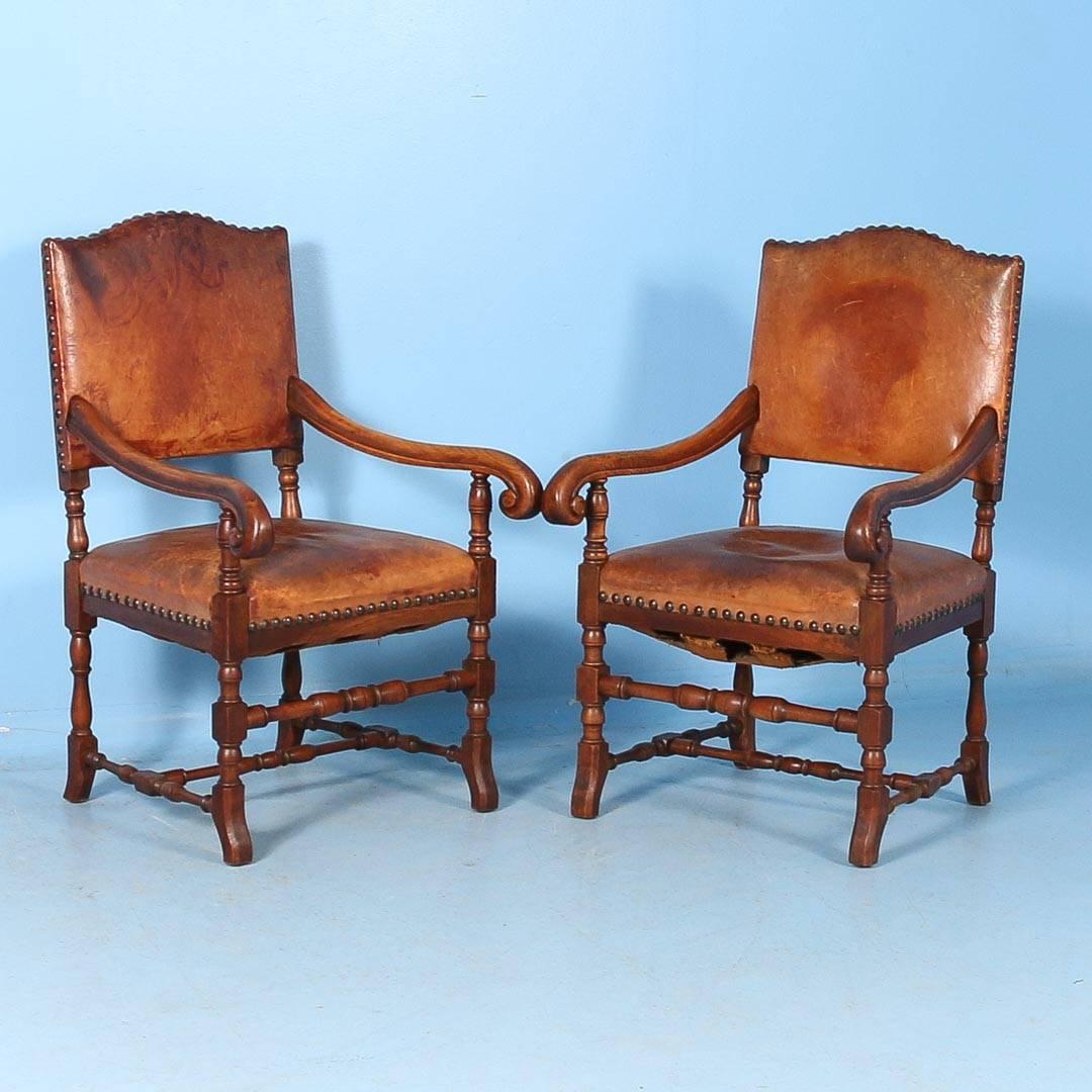 Fabulous matching set of two armchairs and eight side chairs with vintage leather seats and backs from Denmark, circa 1890 in the Baroque style. Brass studs, both decorative and functional, hold the leather in place both at the seat and back. The