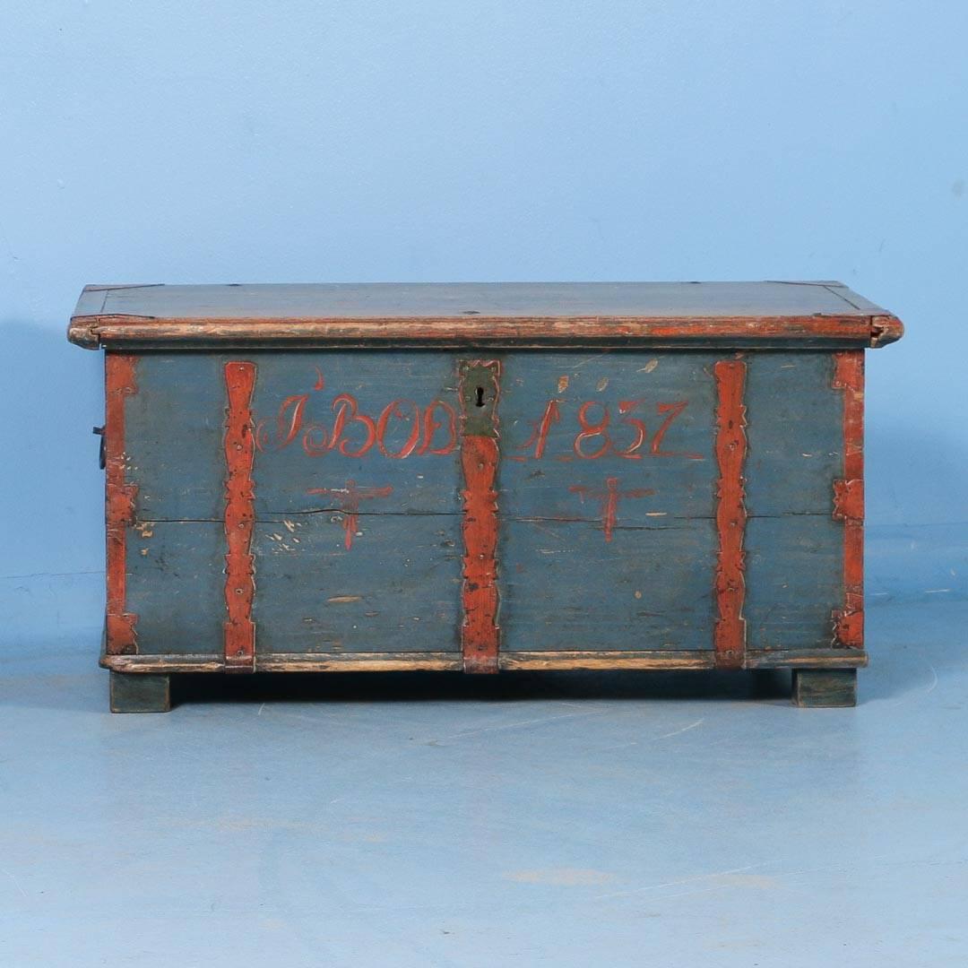 Antique Swedish pine trunk with original soft blue paint dated 1837. The old wrought iron hinges and straps are original but have been painted a rust/burnt orange color. Please review the close up photos to appreciate the exact color for yourself,