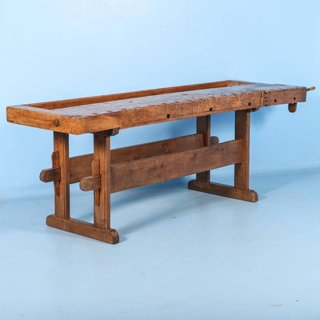 Rustic antique Danish carpenters’ workbench, bearing an incredible patina after years of traditional use. Please examine the close up photos to appreciate the depth of the patina. It has one wooden vice with a wood handle and a recessed tray where