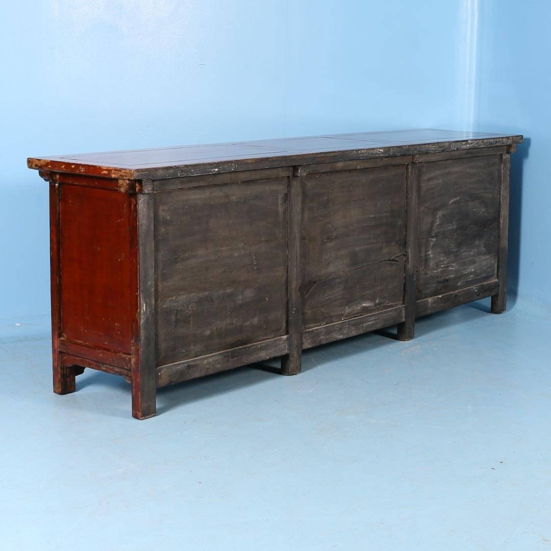 Antique red lacquered sideboard from Shanxi Provence, China. The original red painted finish has been worn down in places to reveal the natural elm wood below, which creates depth and character in the piece. Please examine the close up photos to