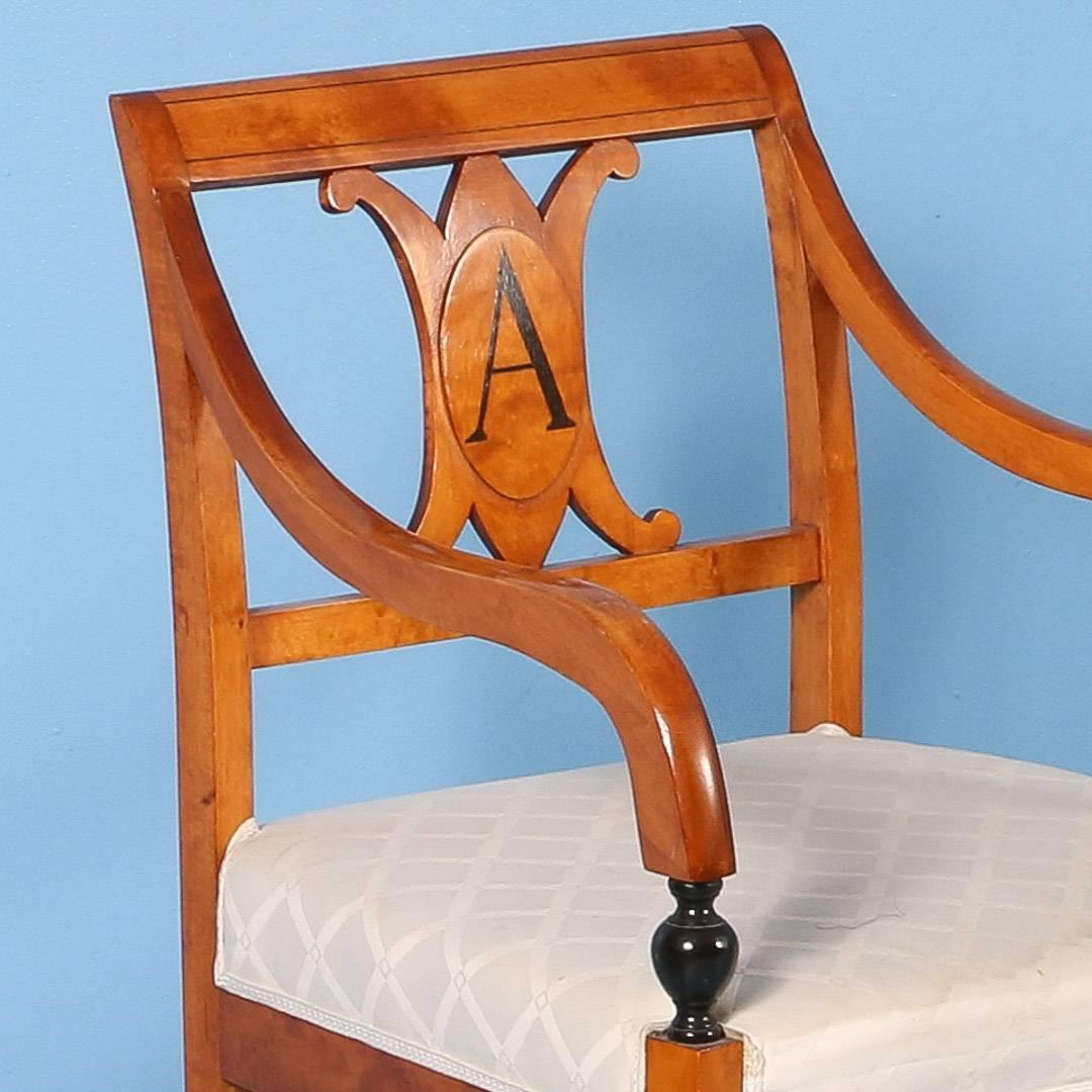 This elegant pair of Swedish Karl Johan birch arm chairs boast a handsome 